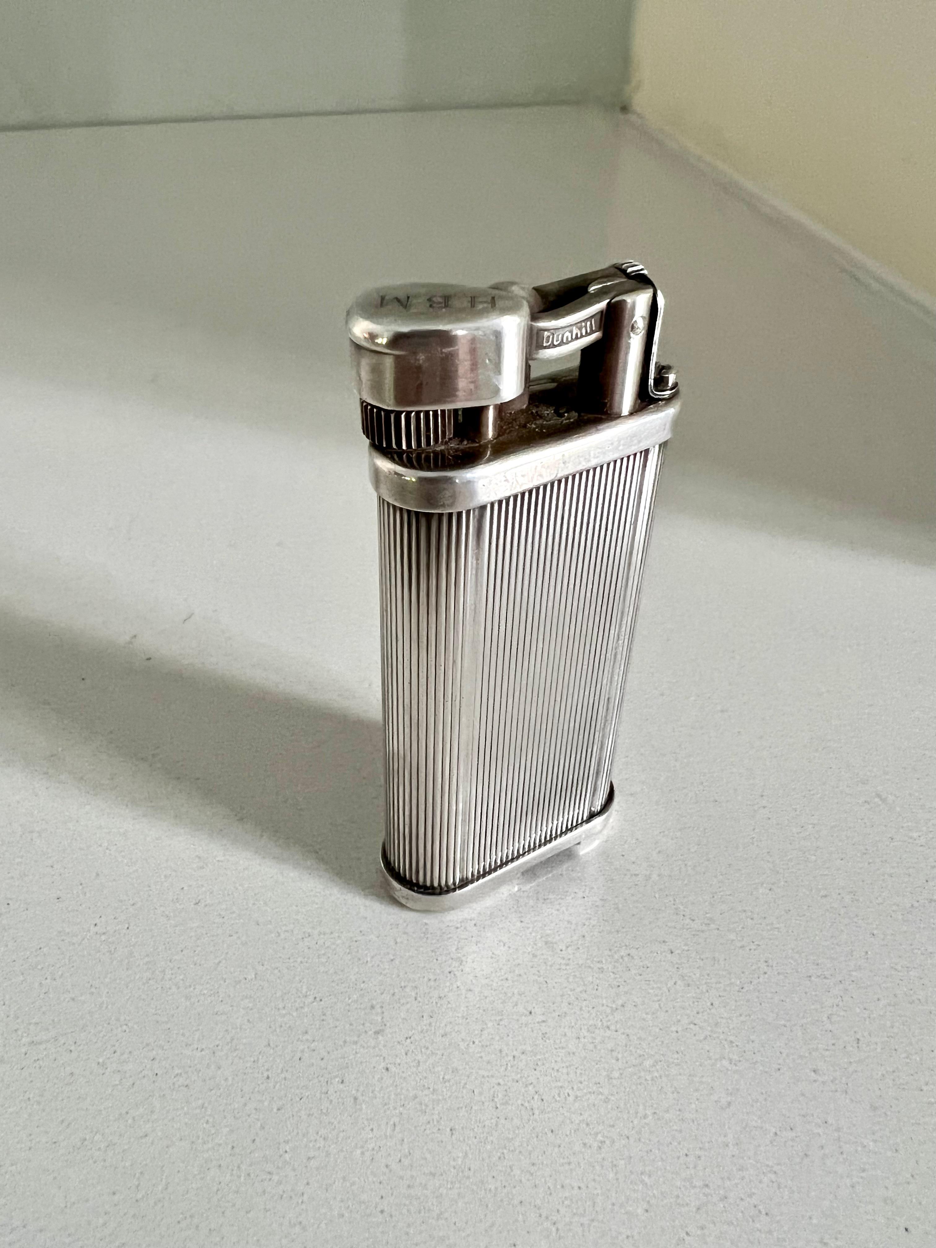 Dunhill silver-plate Unique pocket lighter. Silver plated brass in a classic design dating to 1920. Fine pinstripes etched vertically into the body. A good weight to this pocket lighter. In great working condition. 

As seen in James Bond: License