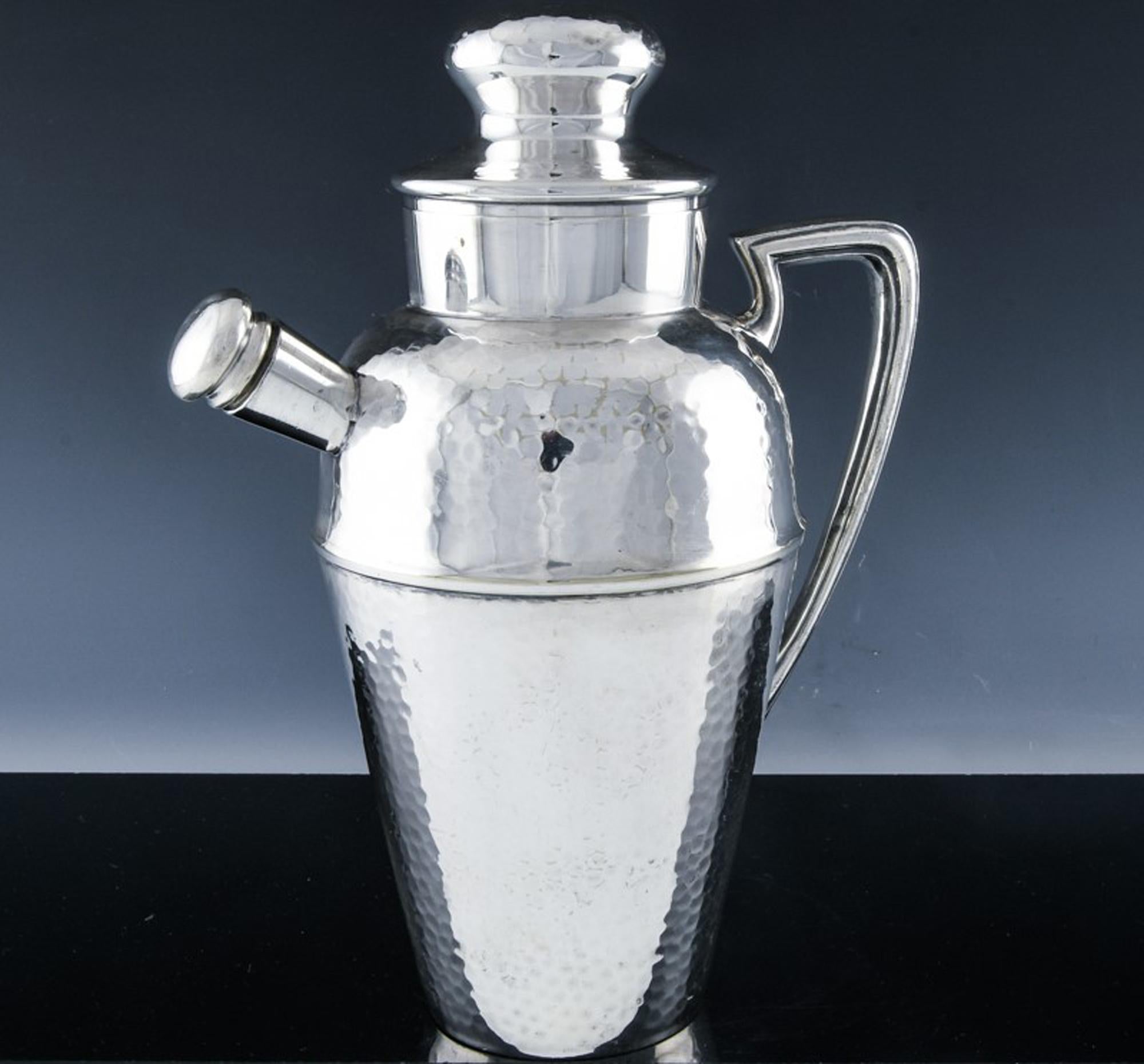 Silver plate cocktail and Martine shaker and pitcher,
1930s
(Ref: 9475-unx)

This cocktail shaker is a very fine quality silver plate example. The body is hammered and has an Art Deco form.

The interior has a wide perforated lip so one can