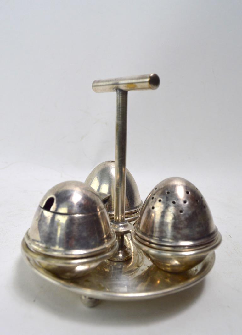 Silver plate condiment set made in England Aesthetic Movement design after Christopher Dresser. Silver plate finish shows minor wear, normal and consistent with age.