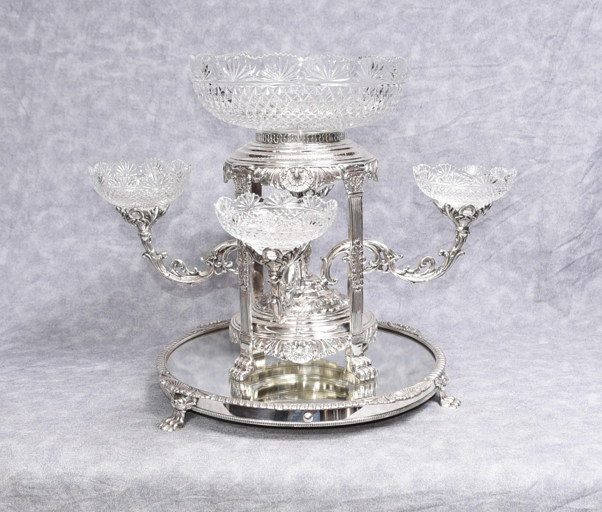 You are viewing an incredible pair of Sheffield silverplate and cut glass epergenes in the manner of Matthew Boulton. The pair have been crafted from silver plate and crystal glass and stand on the mirrored silver stands.

It's really hard to know
