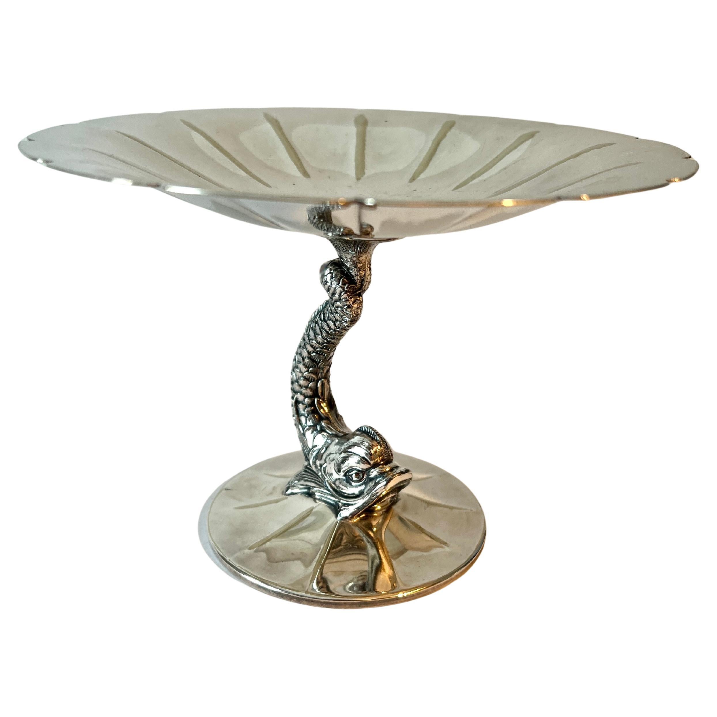 A stunning silver plate dish with dolphin pedestal.   the round top has a fluted and indented unique design.

The dish is in good condition and very decorative.   The piece can be used to display custom candies, business cards or as a stand alone