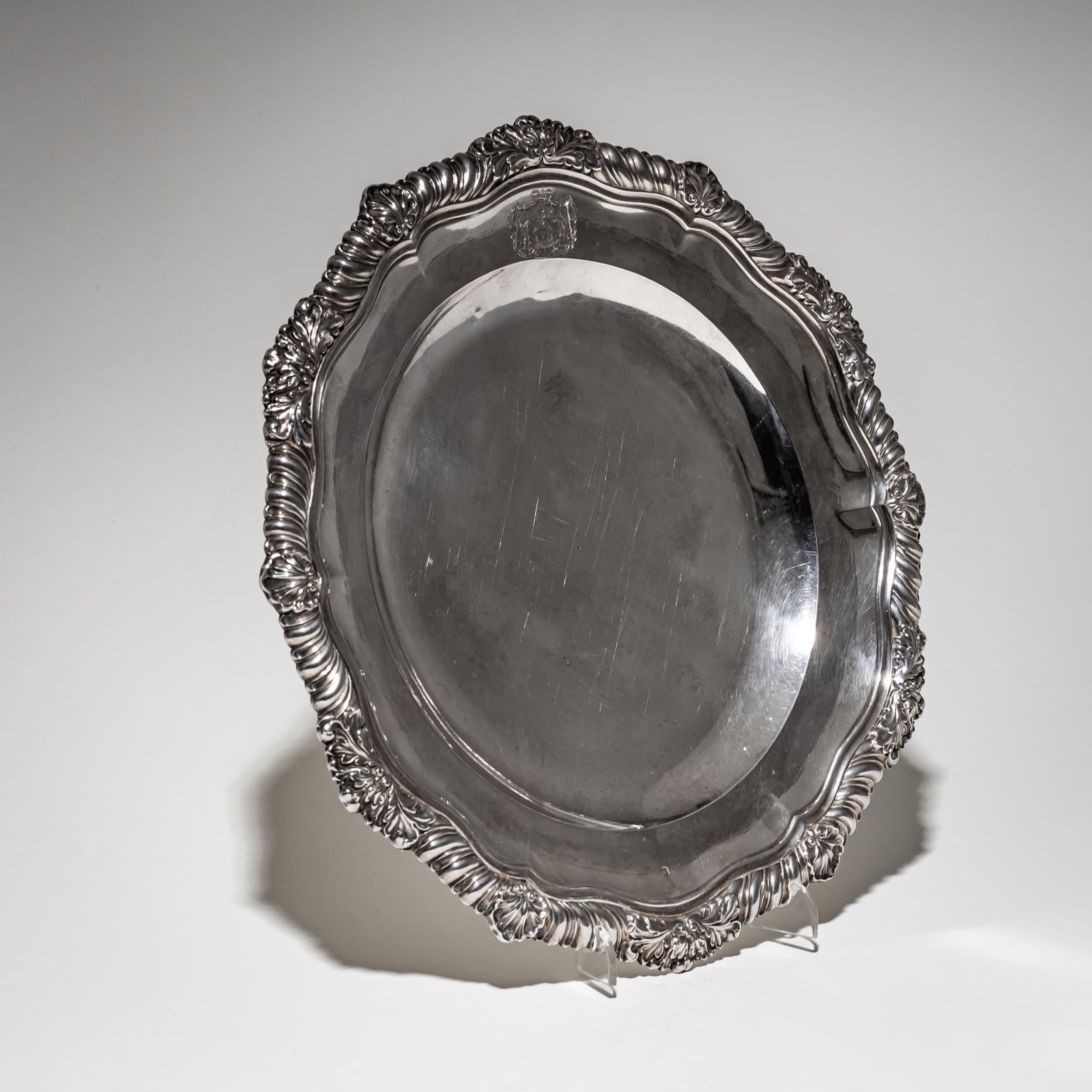 Elegante piatto d'argento con pozzetto liscio, bordo smerlato e gadrooned ornato con motivi di conchiglie e foglie. Lo stemma inciso della famiglia principesca Lieven è ben visibile sulla parete. Marchio di fabbrica Lebrun, Francia, prima metà del