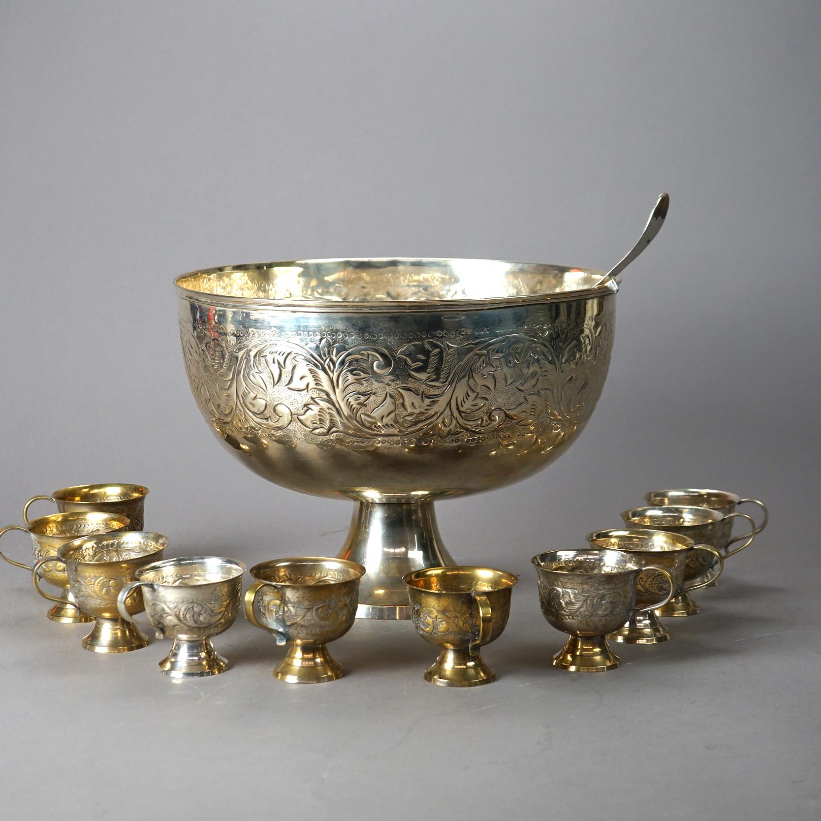 A formal punch bowl set offers silver plate construction with embossed foliate decoration, raised on flared plinth; set includes bowl, ten cups and ladle; 20th century.

Measures - Bowl 10.5