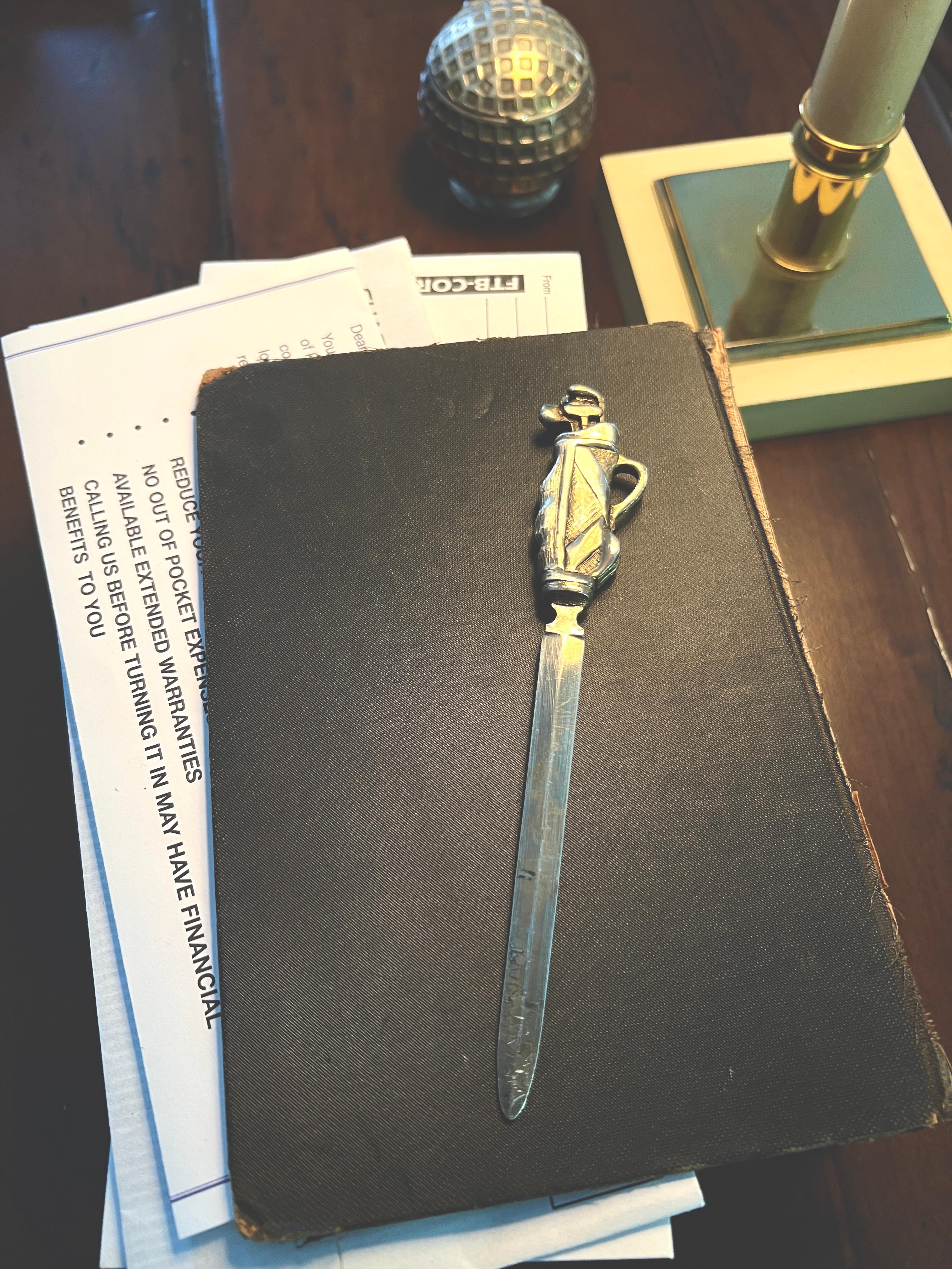 Un bonito abrecartas chapado en plata con un mango bien detallado de una Bolsa de Golf.  

La pieza es un complemento para cualquier escritorio o puesto de trabajo y especialmente para los aficionados al Golf.  Si tu pareja es Tiger Woods, ¡esto