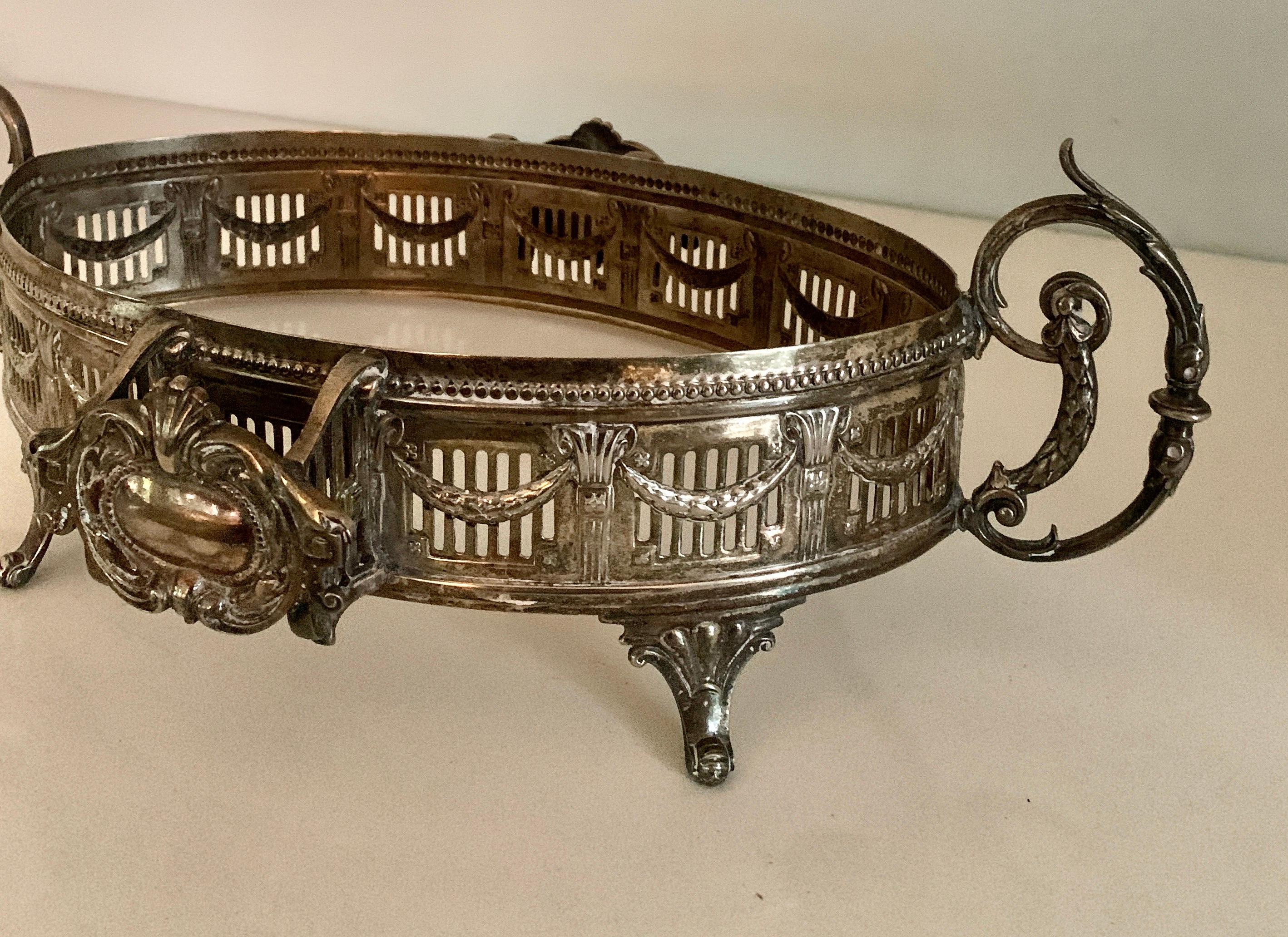 A wonderful and very detailed silver plate tray with wide gallery. Details include handles, and a rope / sash movement around the tray. The piece would be wonderful as a decorative piece on a coffee or cocktail table, for serving small dishes or