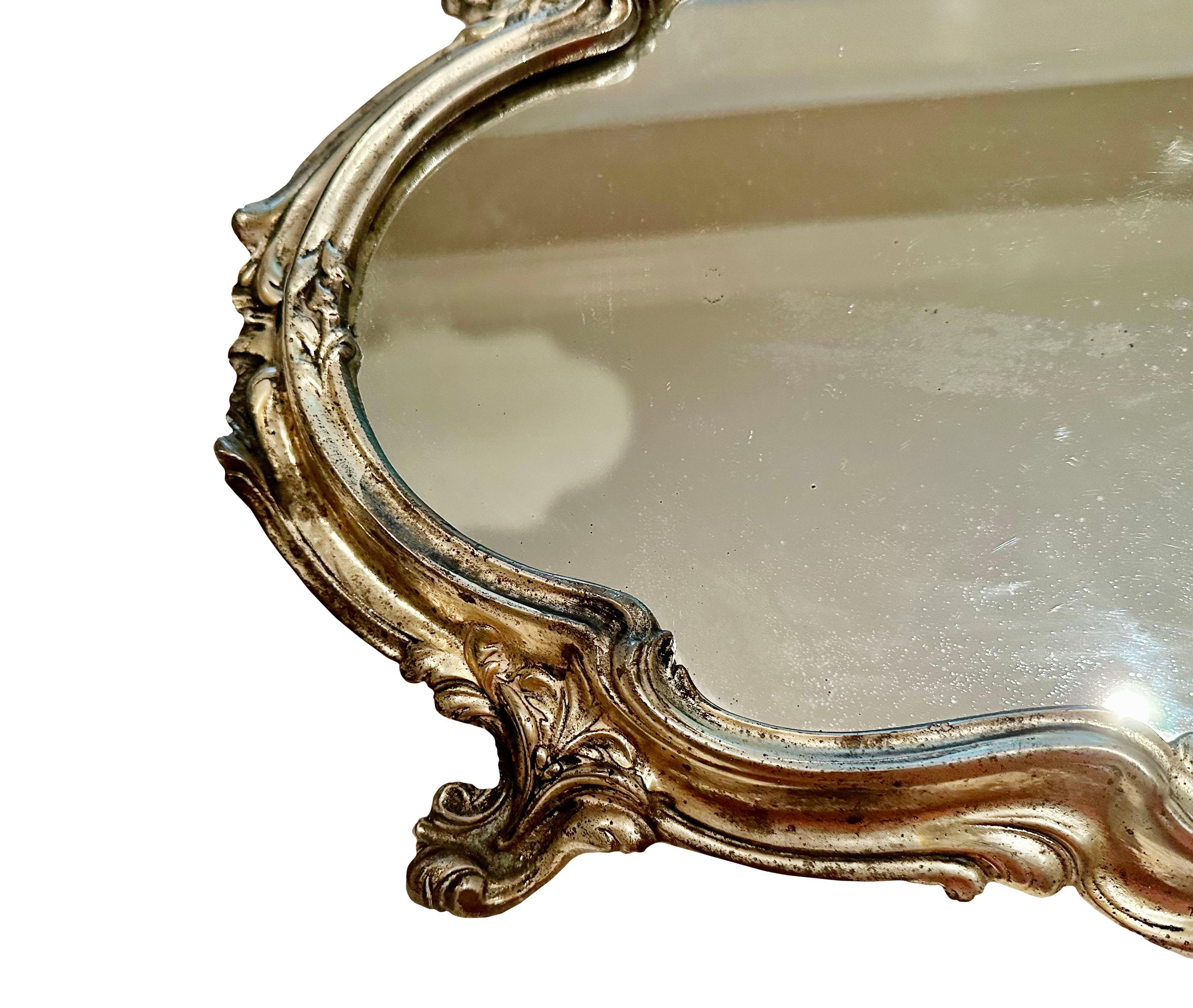 A beautiful French Rococo style silver plate plateau. Footed with a mirrored top. circa 1920s, France.