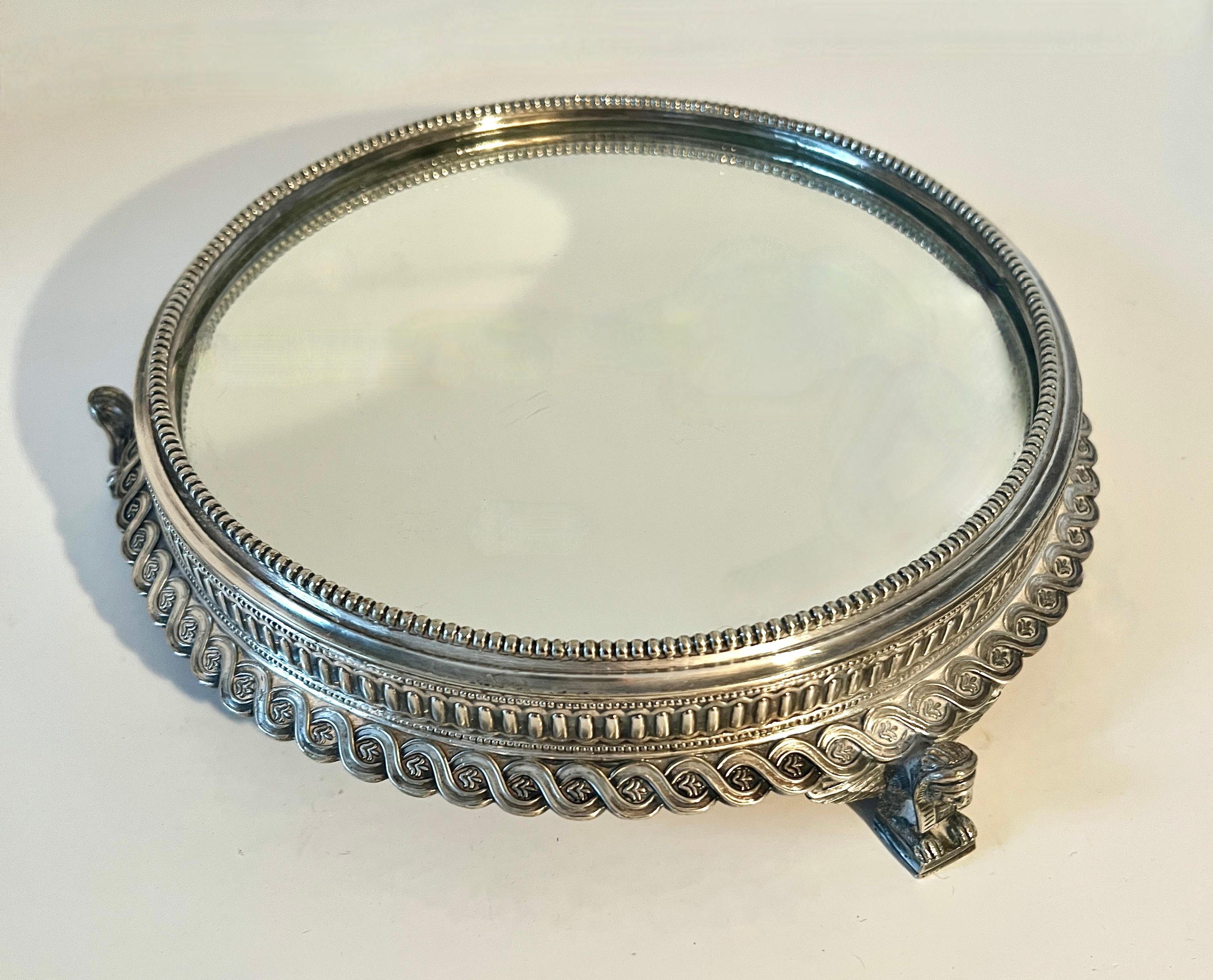 Beautiful Round Silver Plate Plateau.  The 19th century piece is perfect for the vanity, dressing table or bathroom.  

With a modern design a compliment to any space as the lines and design are very architectural and graceful.   Feet are Sphinx and