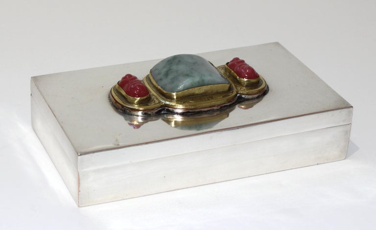 This stylish and chic storage box dates to the 1920s-1930s and is silver plated with a Chinese buckel mounted as a cartouche on the top. The buckel is fabricated with three carved jade pieces, and a brass surrrond with the good luck symbol of bats.