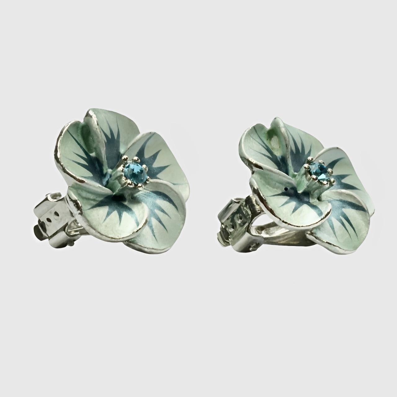 Silver plated and blue enamel flower clip on earrings, with blue rhinestones.

Measuring diameter 2.15 cm / .8 inch. There is some wear to the enamel.

This is a pair of beautiful silver plated and enamel flower earrings.