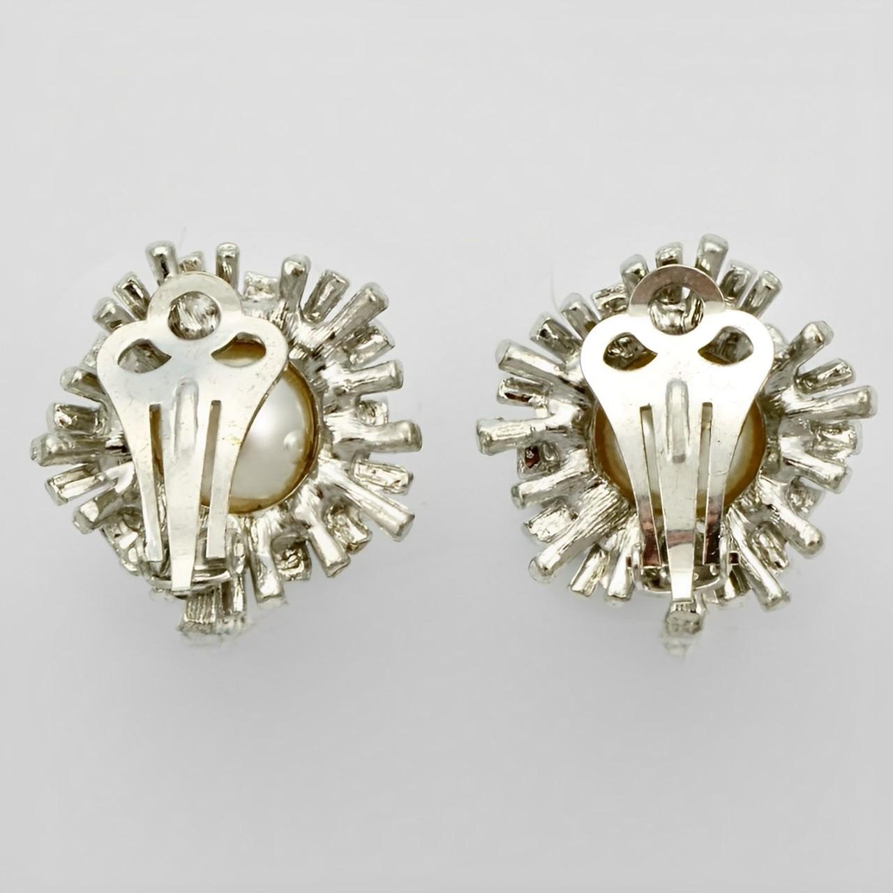 Orecchini a clip placcati in argento con perle finte bianche circondate da un disegno a stella. Misura 2,2 cm di diametro e 1,3 cm di altezza. Gli orecchini sono in ottime condizioni.

Questo è un bellissimo paio di orecchini classici in stile