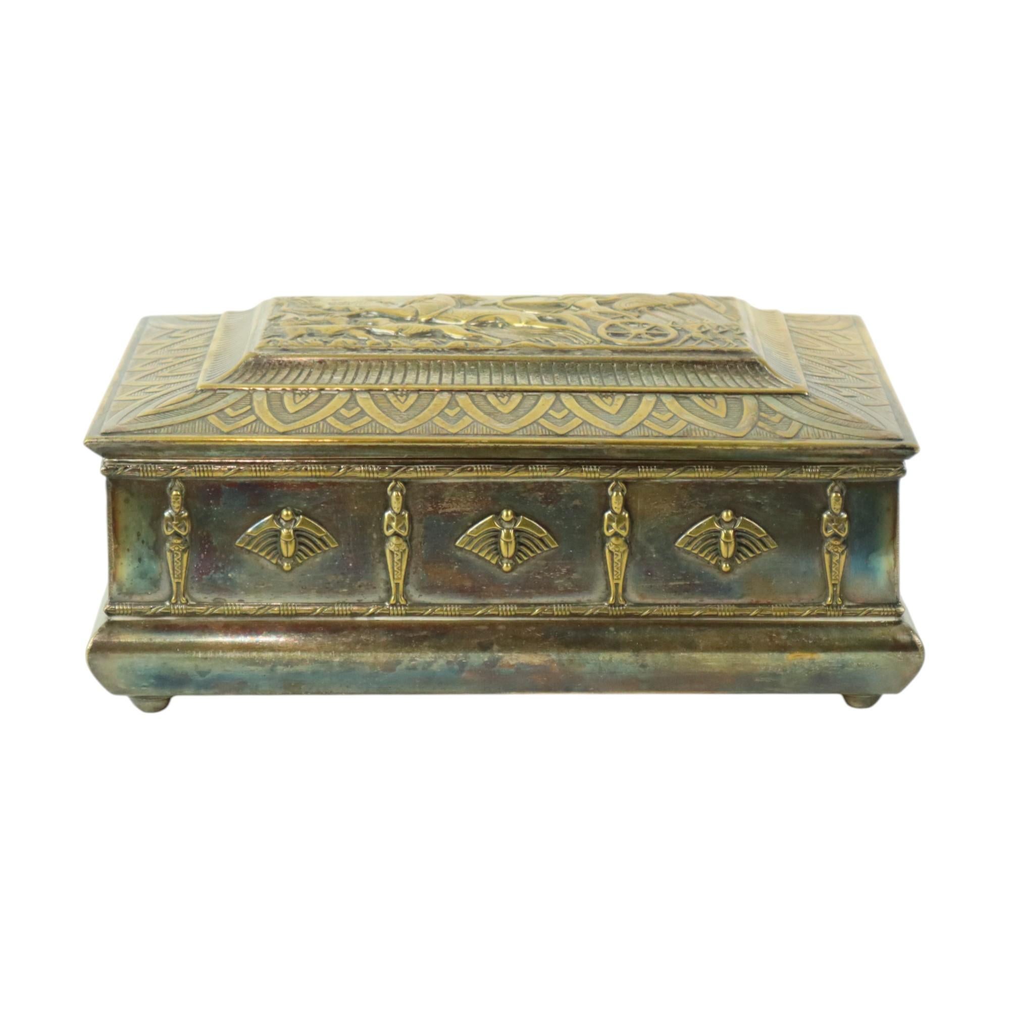 A unique Art Deco chest, perfect as a jewelry or trinket box. Decorated with Egyptian motifs in bas-relief, the top depicts a hunting scene with a chariot drawn by horses, reminiscent of designs by Max Le Verrier. Made by Mussbach Germany, it is