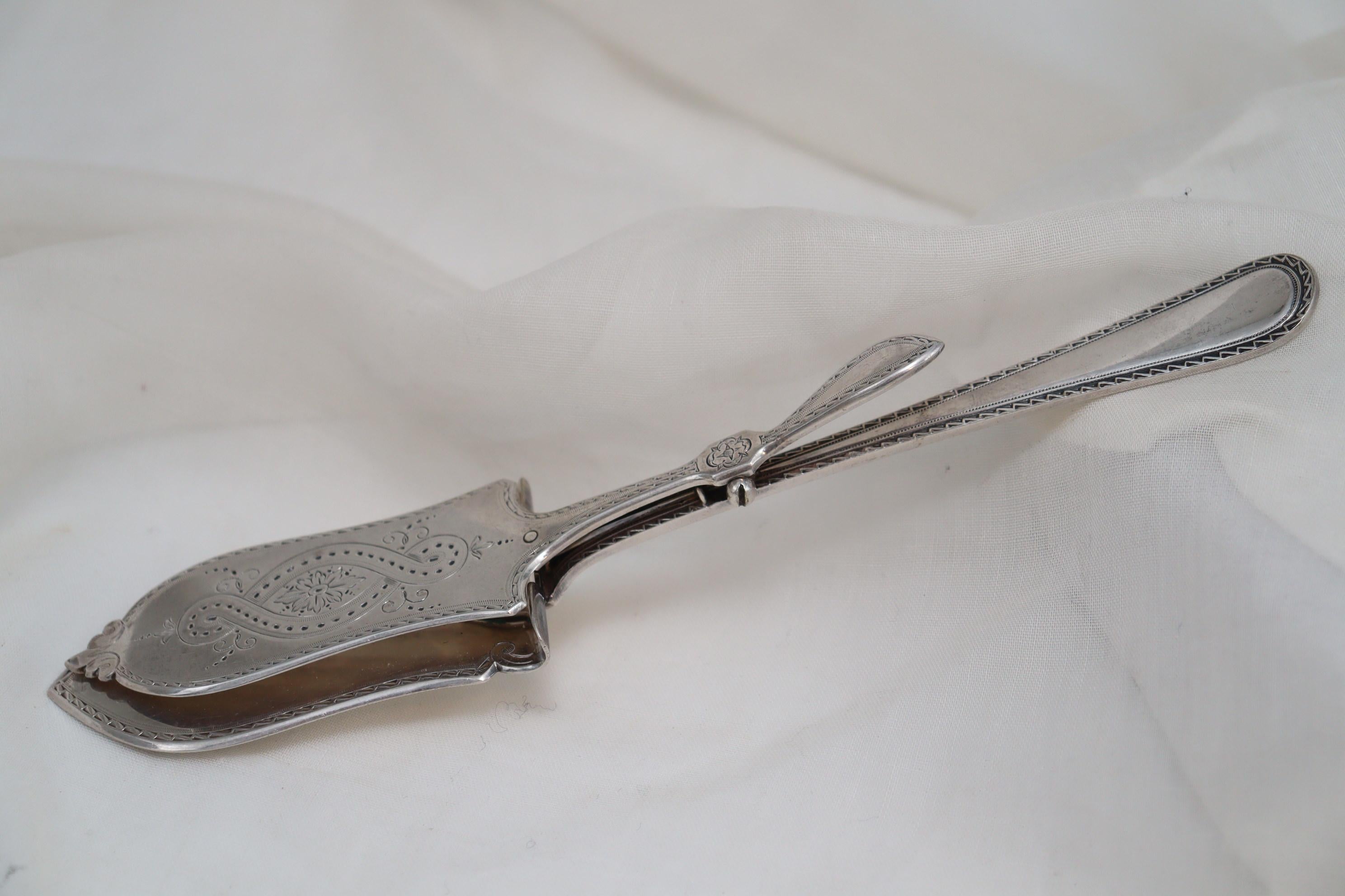 These ornately decorated silver plated asparagus servers were made by Elkington & Co of Birmingham England. They measure 242 mm (9.5 inches) in length, are 48 mm (1 7/8ths inches) at the widest point and stand 19 mm (.75 inches) high. They are in