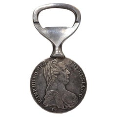 Apribottiglie placcato argento con un tallero di Maria Teresa – Austria 1950