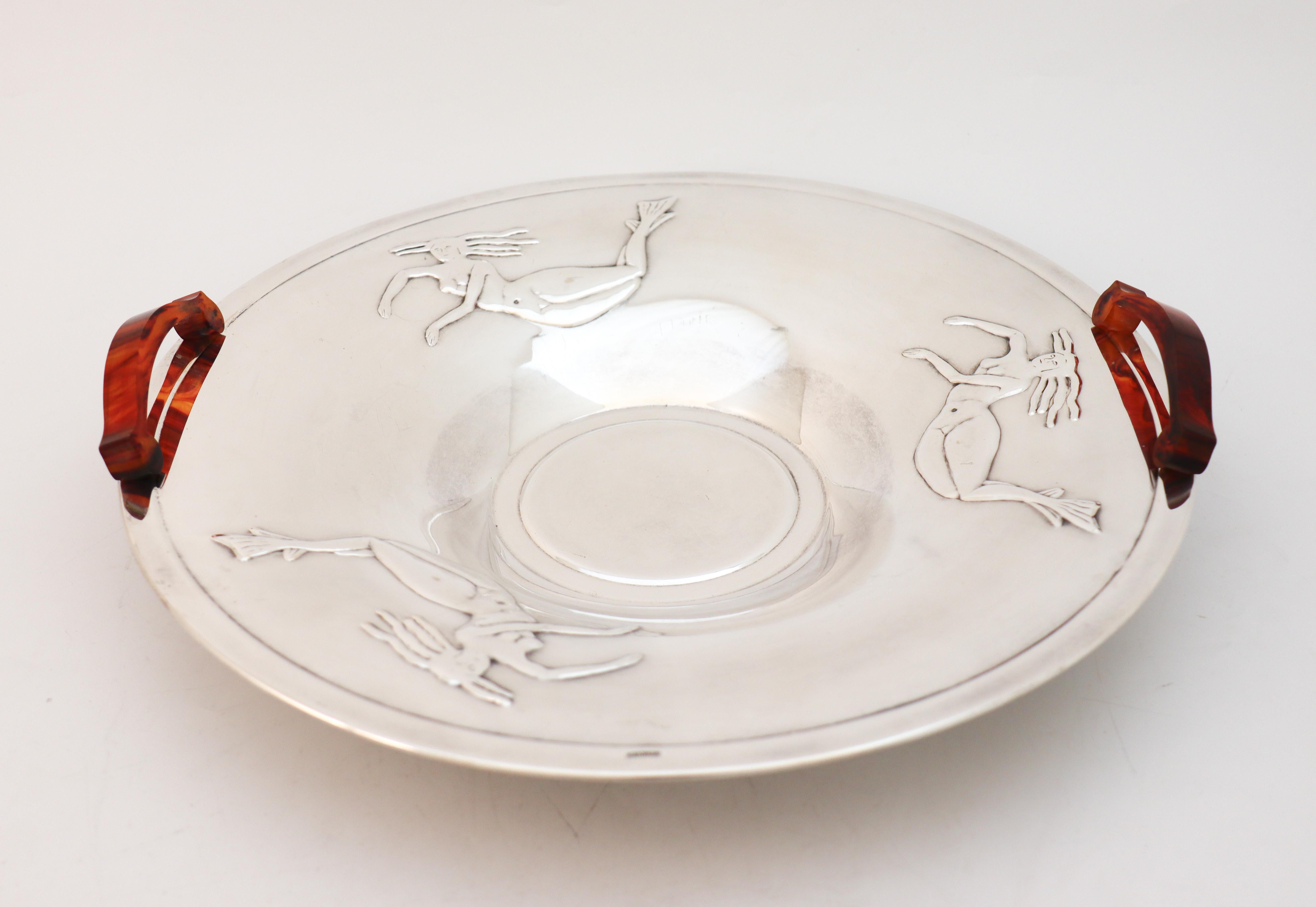 A lovely silver plated bowl with handles in amber or plastic. The bowl has a lovely decor of mermaids and is made in the 1930s or 1940s, it is made in lovely Swedish modern style. It is 35 cm (14