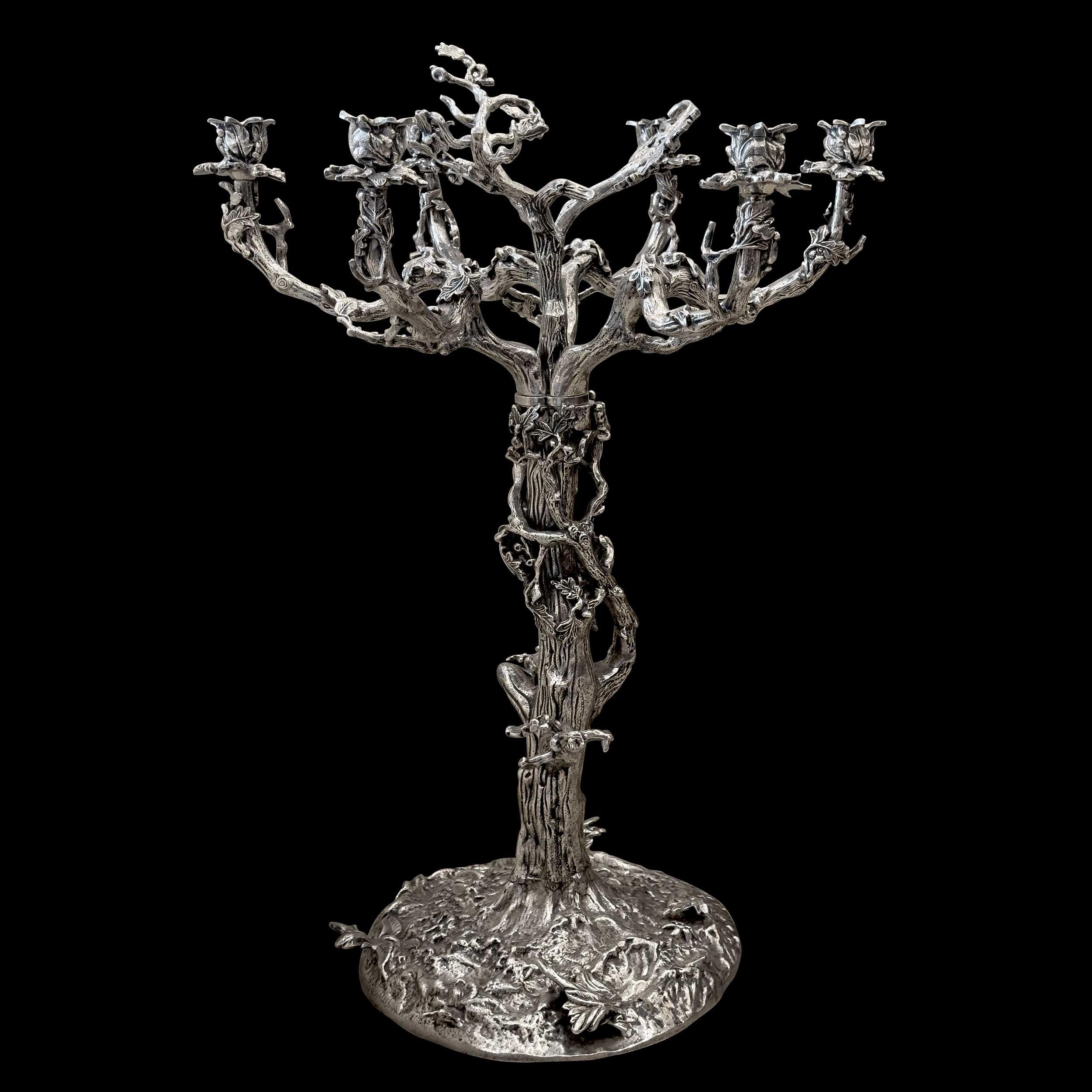 Grande candelabro argentato con sei rami frondosi su un tronco d'albero contorto. Si ispira allo stile dei pezzi del Vieux Christofle. Quest'opera, ispirata ai bronzisti animalier del XIX secolo, mostra un notevole realismo.

Questo candelabro è