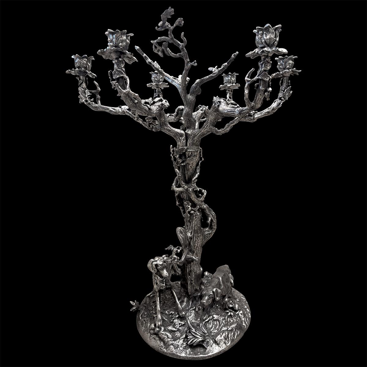 Grande candelabro argentato con sei rami frondosi su un tronco d'albero contorto. Ispirato allo stile dei pezzi vintage di Christofle, questo candelabro presenta una base ornata da due cani da caccia, uno dei quali è in punta. Quest'opera, ispirata