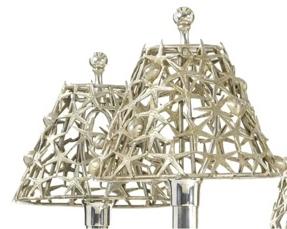 Lustre italien à six lumières en métal argenté, dans le style Buccellati.  

Conçue avec des motifs marins, la couronne moulée de coquillages surplombe une cage de corail incrustée de fruits de mer moulés individuellement. Les six bras de bougie