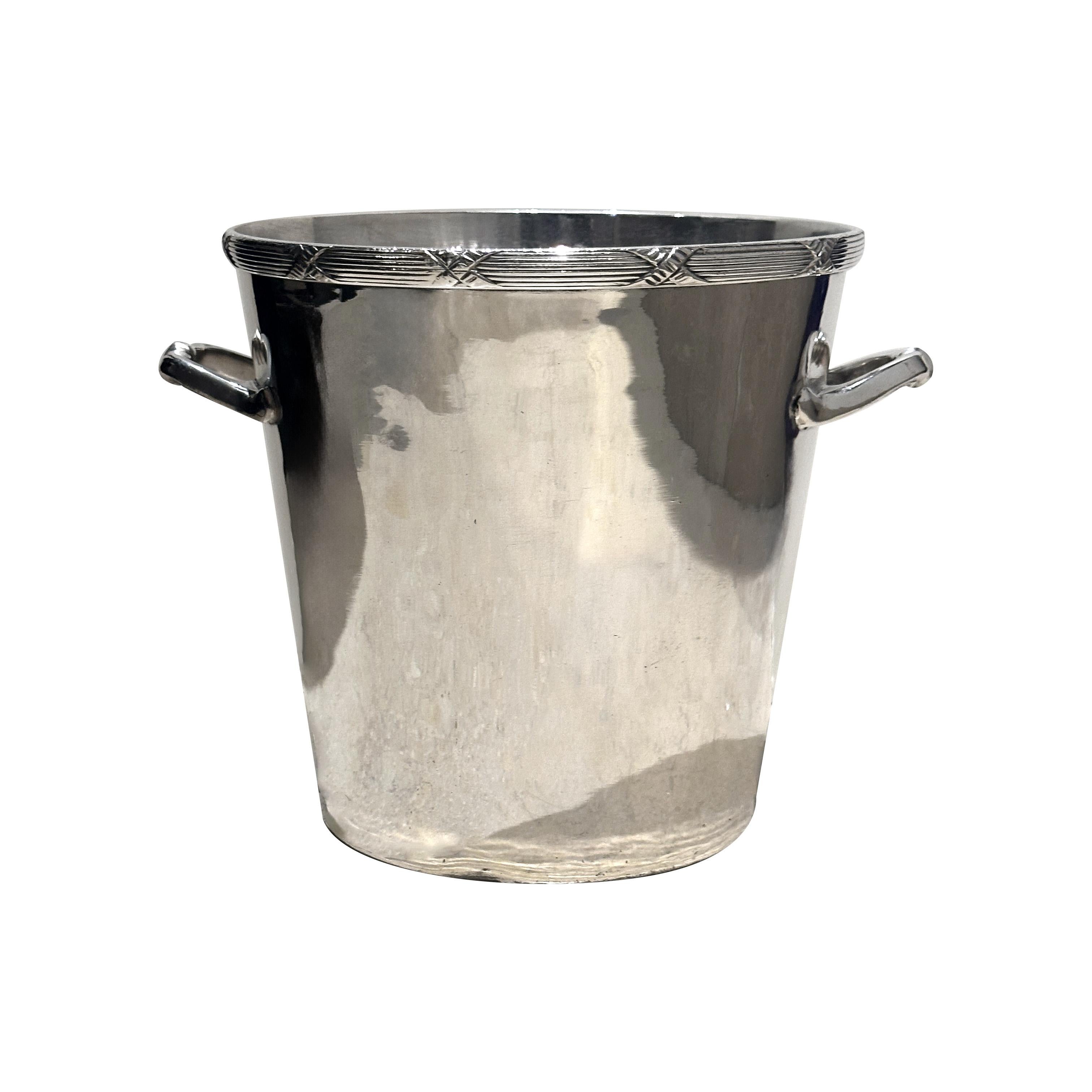 Cet exquis seau à champagne plaqué argent provient de Ladurée, l'emblématique pâtisserie française réputée pour incarner l'élégance et l'art de vivre à la française. D'une beauté intemporelle, le seau présente un design épuré et raffiné, rehaussé