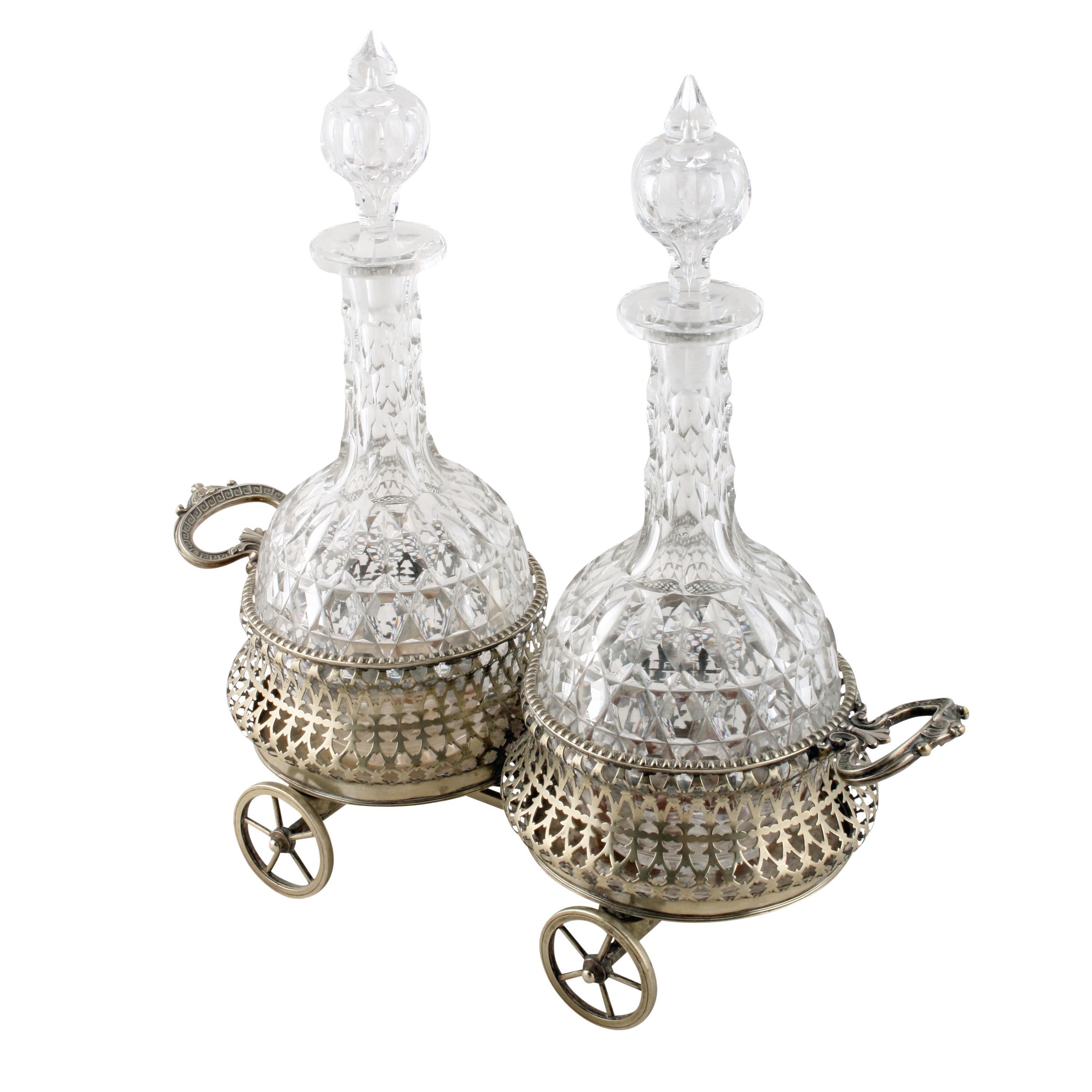 A Victorian silver plated wine coaster wagon and decanters.

The wagon has a pair of open work coasters that are mounted on four open spoke wagon wheels.

The wagon has a carrying handle at each end that is decorated with a Greek key