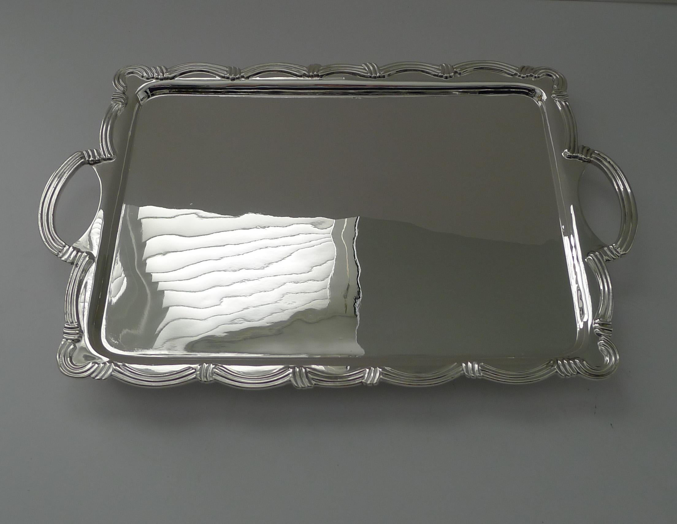Ein wirklich schickes und ungewöhnliches Cocktail-Tablett mit Henkeln und einem schönen, erhabenen Rand, der um das Tablett herumläuft, sowie zwei Griffen.

Das auf vier originalen Füßen stehende Tablett ist gerade aus meiner Silberschmiedewerkstatt