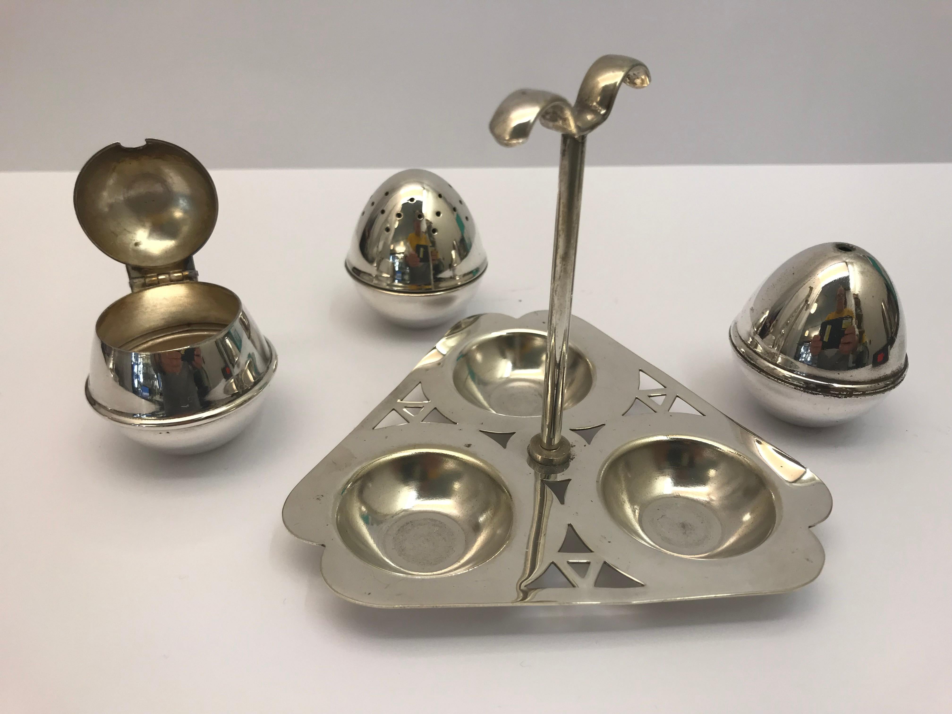 Silver plated condiment set comprising of a salt a pepper and a Mustard pot standing on a triangular pierced frame.
 
Made in England, circa 1930 
Stands 9.5 cm tall.