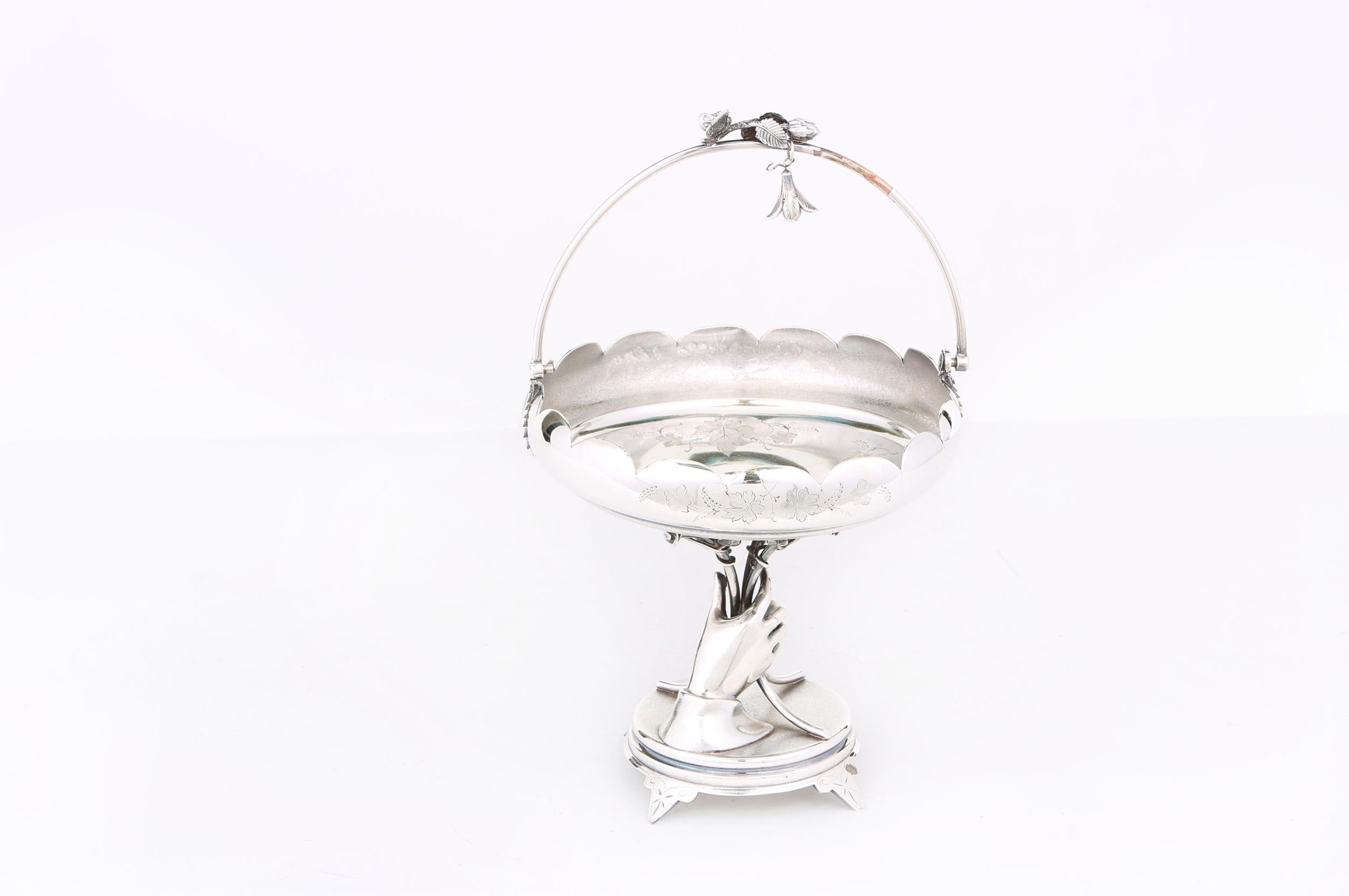 North American silver plated centerpiece in the form of a basket held by a silver plated hand on four twigs with flowers mimicking a bouquet. Great antique condition with minor wear consistent with age / use. Maker's mark undersigned 