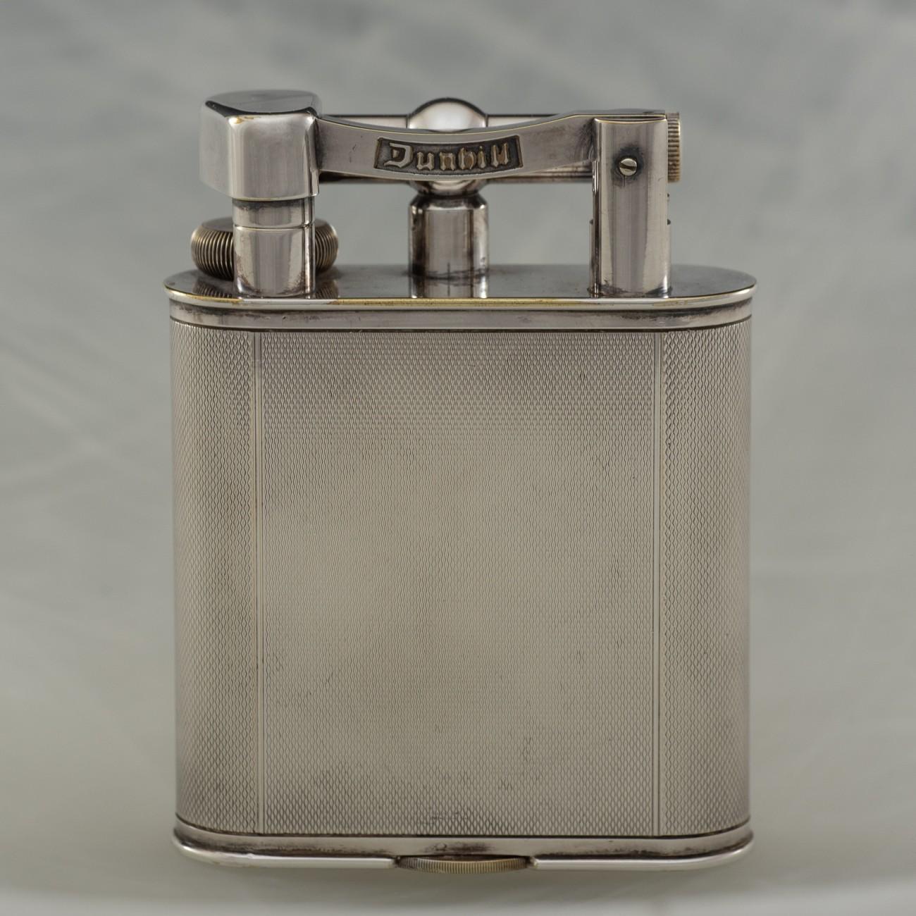 An engine turned silver plated Dunhill 'Giant' lighter; circa 1948. The 'Giant' table lighter was first seen in the Dunhill catalogue in 1929 and was an immediate success.

Dimensions: 10.5 cm/4 inches (height) x 8 cm/3? inches (width) x 2.5 cm/1