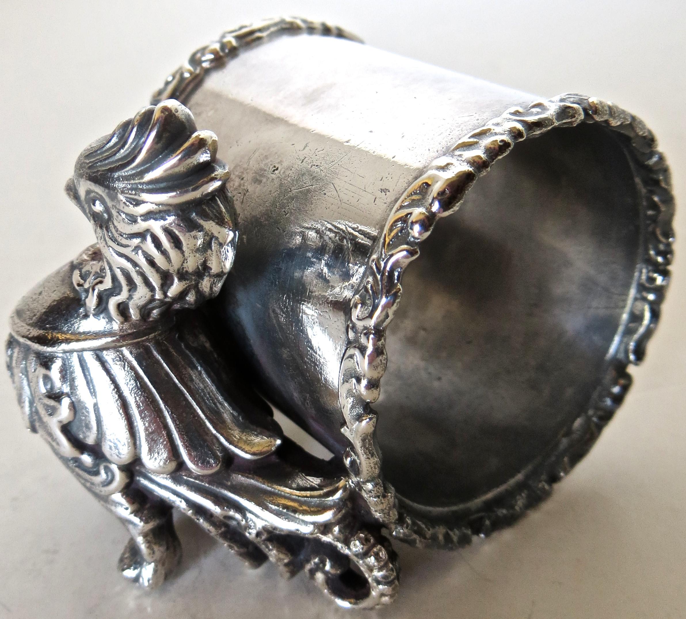 Listed is a silver plated figural napkin ring that I have not seen before and is unmarked. I do not think it is from the Victorian era, but I do believe it was manufactured and somewhat later, say 1920s, not a fake or meant to deceive, simply a