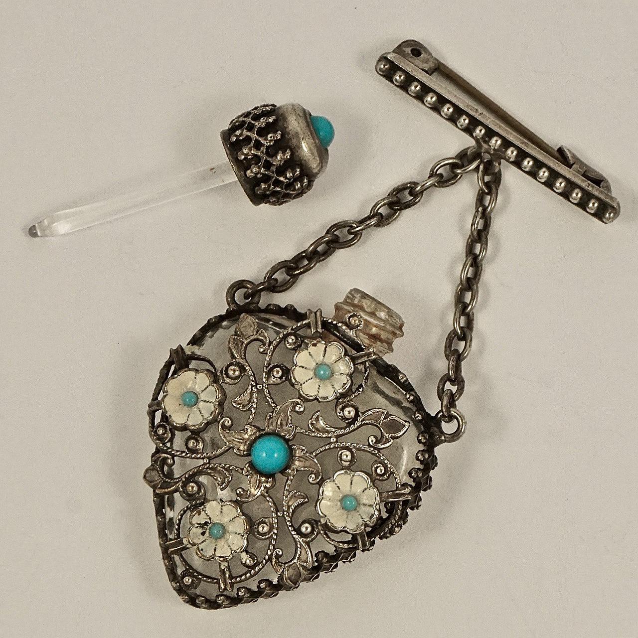 Wonderful silver plated filigree miniature perfume bottle brooch, with turquoise glass and cream enamel decoration. This is a working bottle, the top unscrews and there is a glass dauber, we have not cleaned the inside. The bottle measures length