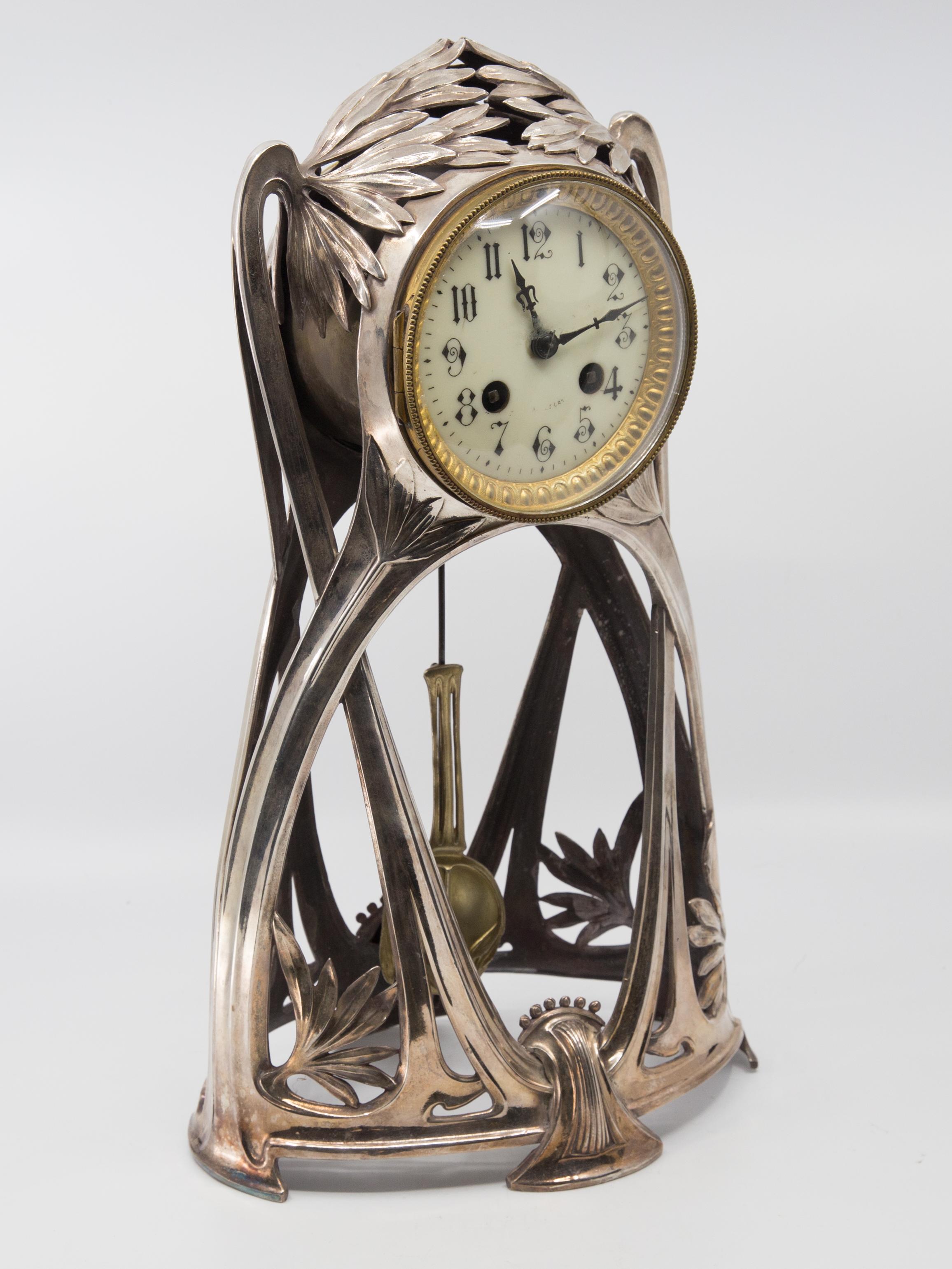 Offered is an exceptionally Art Nouveau silver plated multi metal clock. The body of the clock is silver plated. The clock’s bezel and pendulum are brass trimmed. The piece is really a sculptural and functional work of art. The clock is key wind
