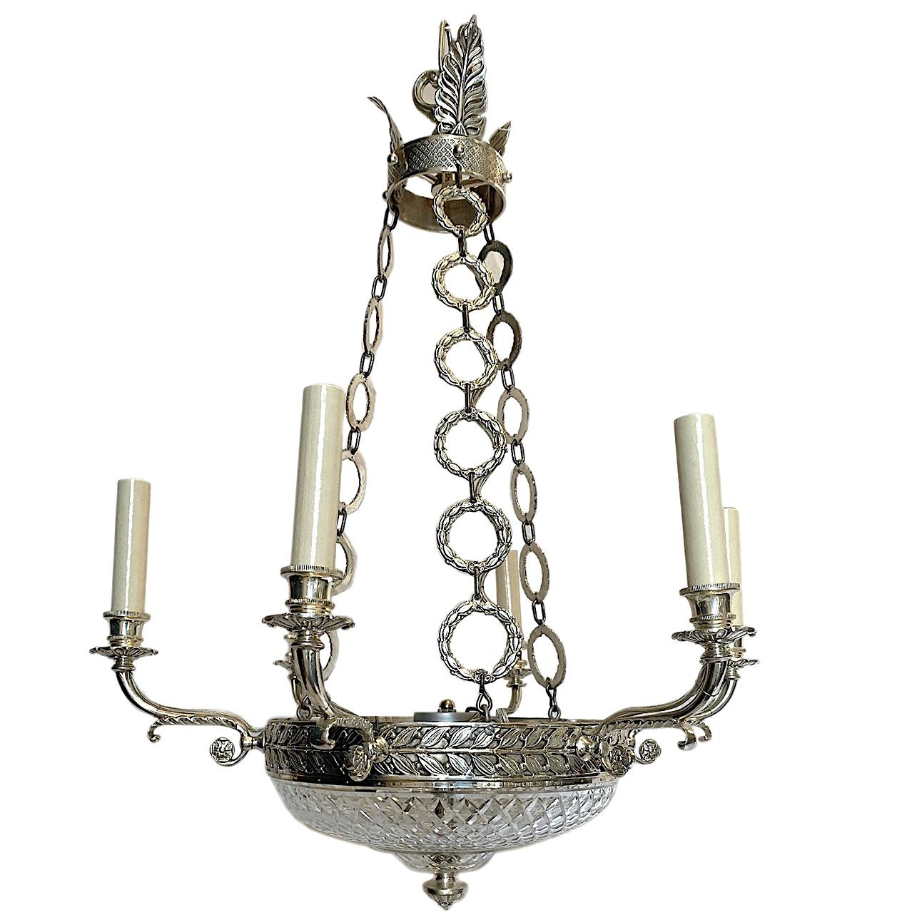 A circa 1920s French silver plated 6-arm chandelier with cut crystal inset and interior lights.

Measurements:
Current drop 27