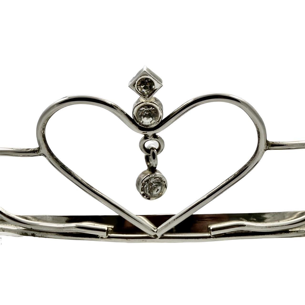 
Lovely silver plated tiara featuring a heart and rhinestone design, with combs at each end. Measuring height at the front 4 cm / 1.5 inches. The tiara is in very good condition, there is very little wear to the silver plating. We replaced a missing