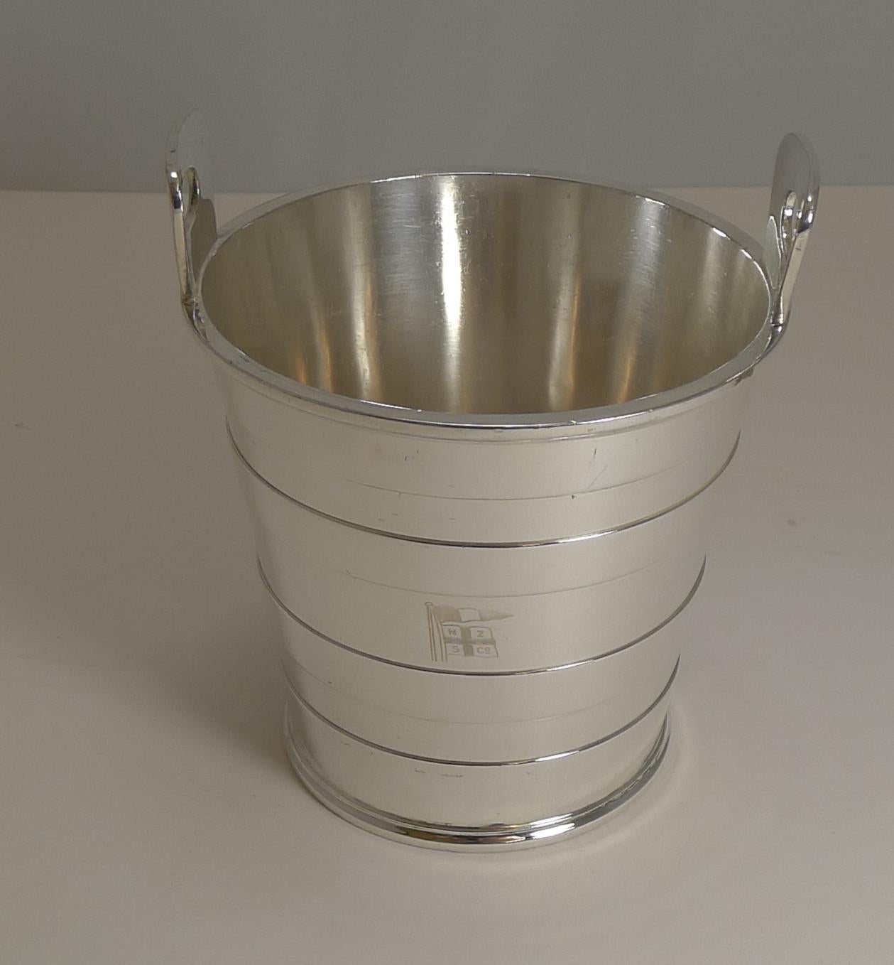 A handsome antique English ice bucket in the form of a bucket or pail, made from silver plate by the top notch silversmith, Mappin and Webb; the underside is fully marked for the silversmith.

The inside has a drainer which sits on a rim on the