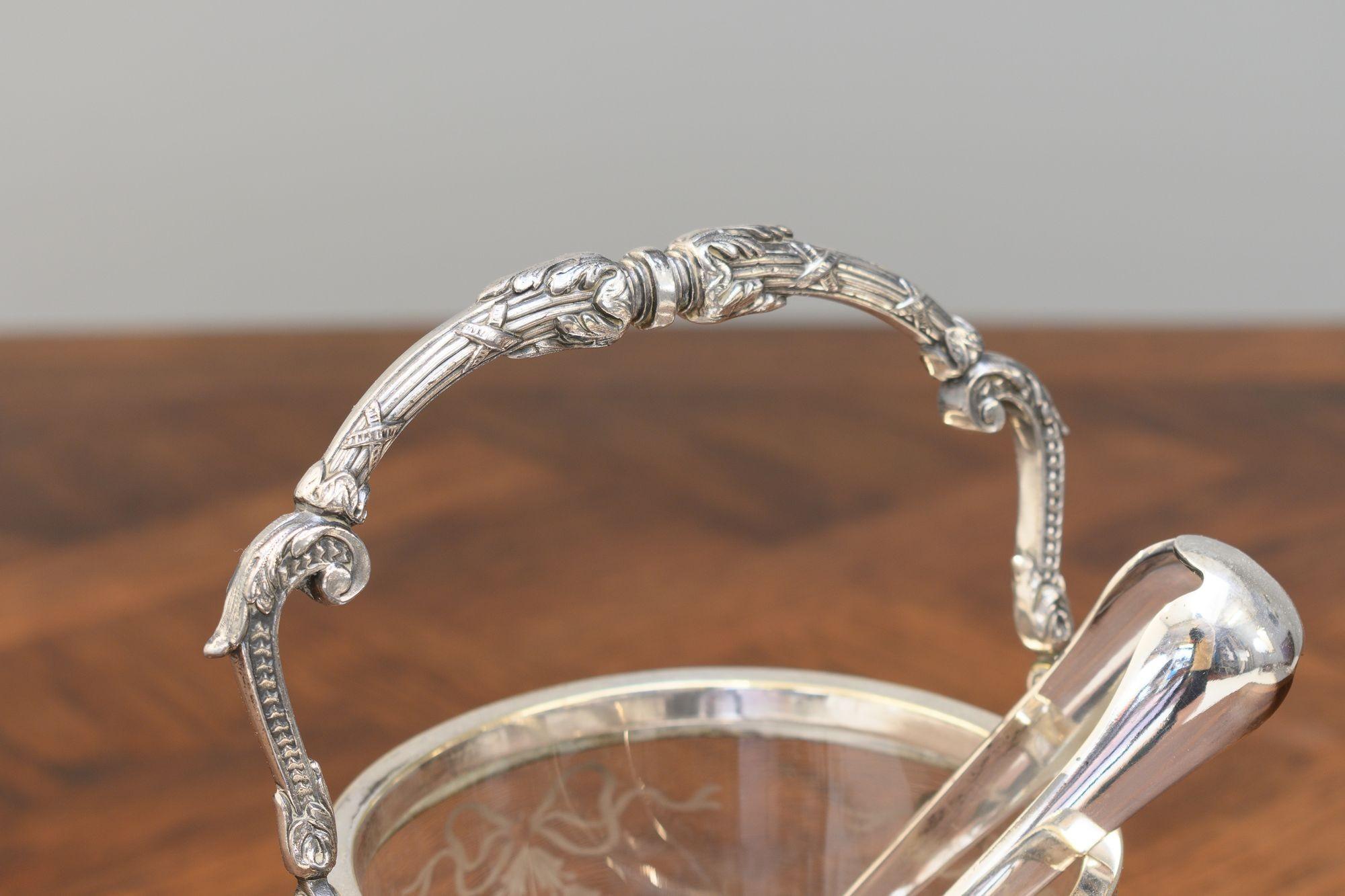 Silver plated crystal ice bucket with handle, strainer and claw tongs. Circa 1900.
H 24cm x W 17cm x D 13cm