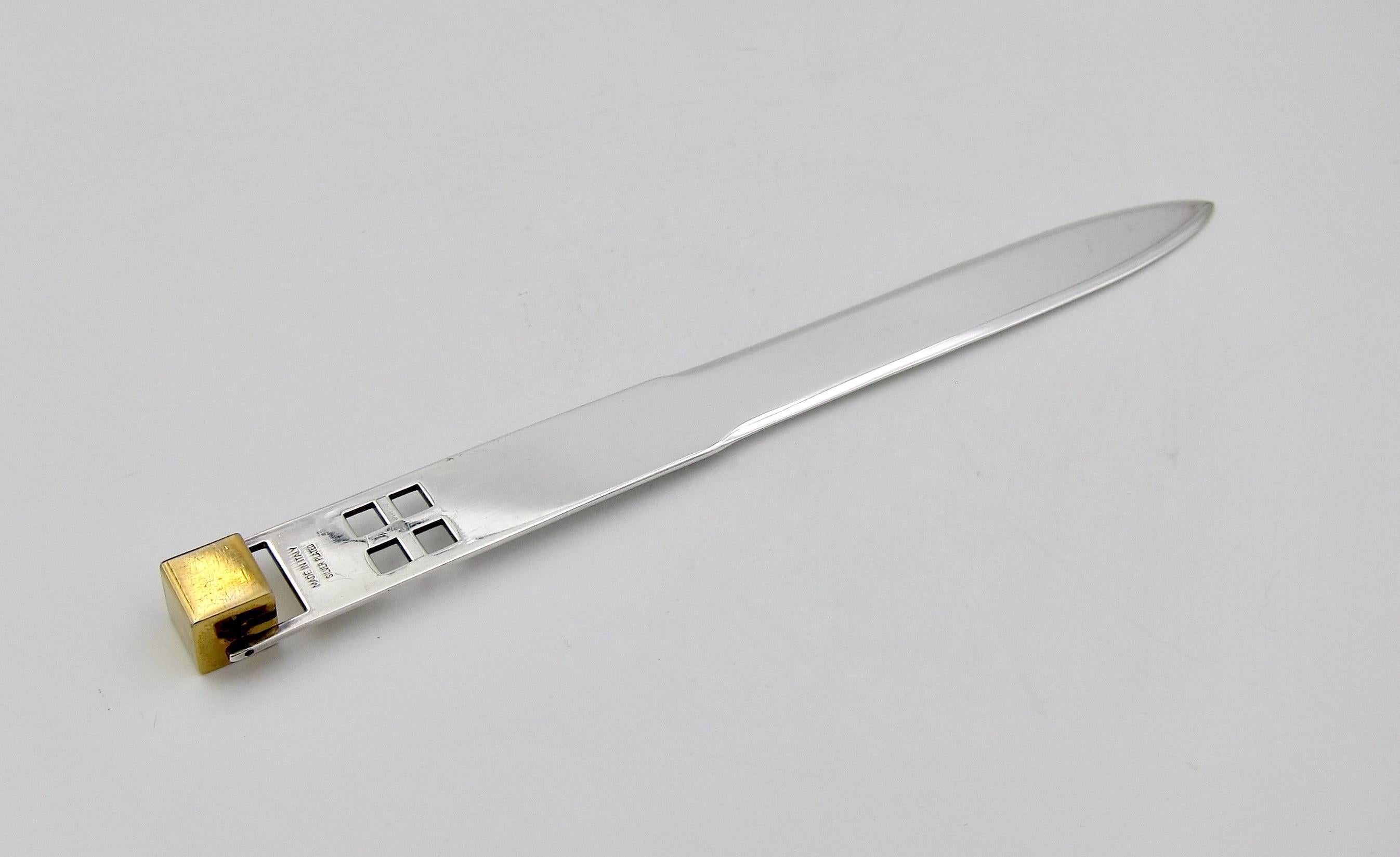 A vintage letter opener / paper knife with a pierced grid of squares under a spinning brass cube, designed in silver-plate by American architect Richard Meier (b. 1934) for Swid Powell in the 1980s. This desk accessory was an offering from Swid