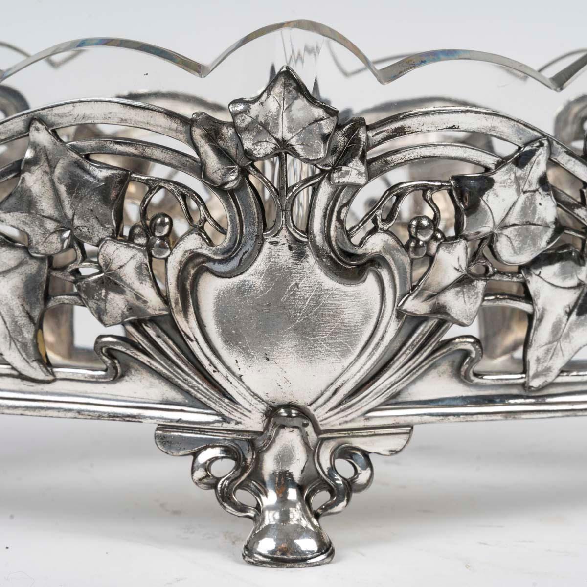 Ciotola in metallo argentato e cristallo, periodo Art Nouveau, 1900.

Una ciotola in metallo argentato e cristallo del periodo Art Nouveau, 1900.
H: 18cm, L: 44cm, P: 16cm