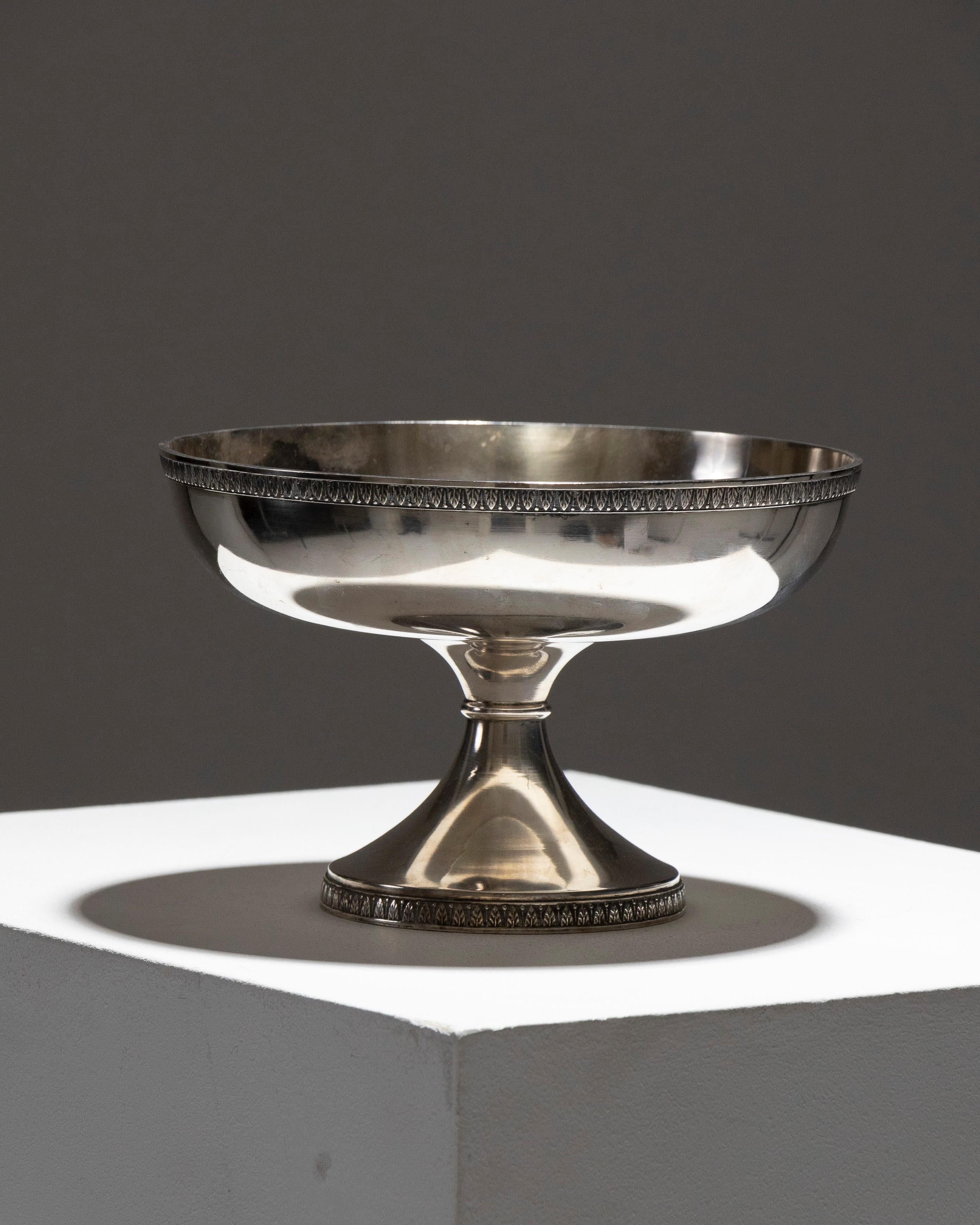 Versilberte Sockelschale aus Metall, verziert mit zwei Palmetten-Friesen.
Seine ausgewogenen Linien und seine elegante Silhouette machen ihn zu einem raffinierten Stück, das sich perfekt für einen Tisch, eine Konsole oder ein Buffet eignet.

Guter
