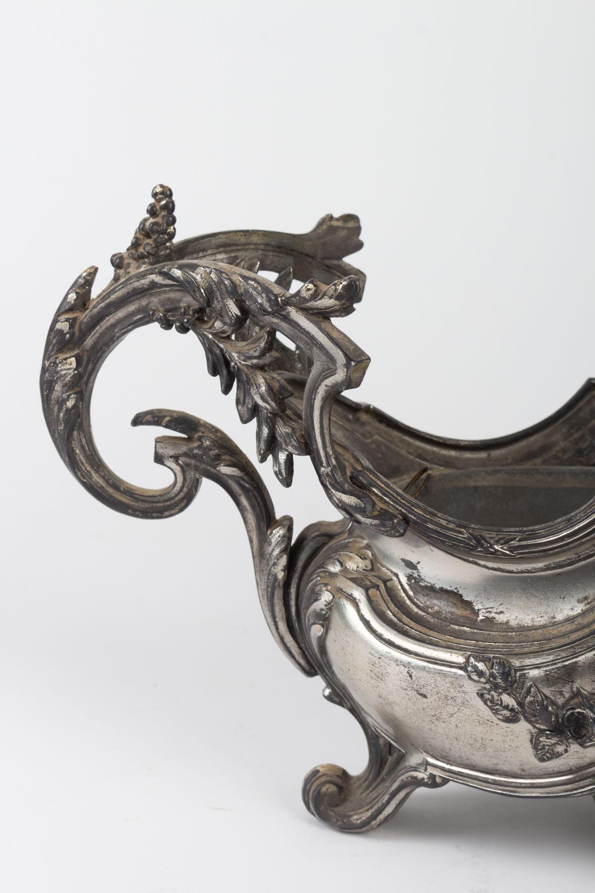 Versilberter Pflanzkübel aus Metall im Louis-XV-Stil, Anfang 20.

Maße: H 16 cm, L 44 cm, D 14 cm.
 