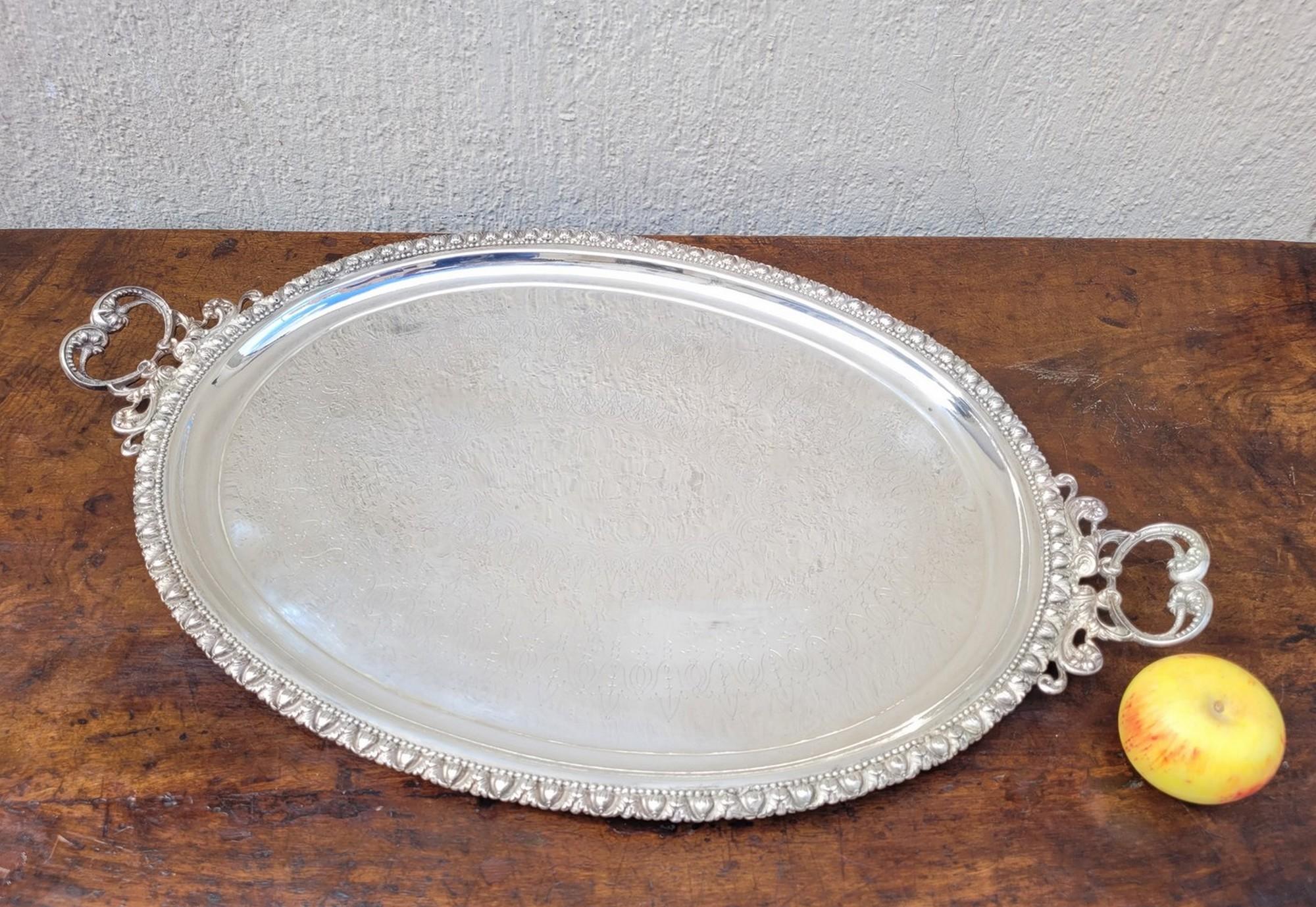 Plateau ovale en métal argenté,  avec poignées et décoration florale.

Traces d'utilisation et légers chocs.
20e siècle.

73.5 x 46 cm