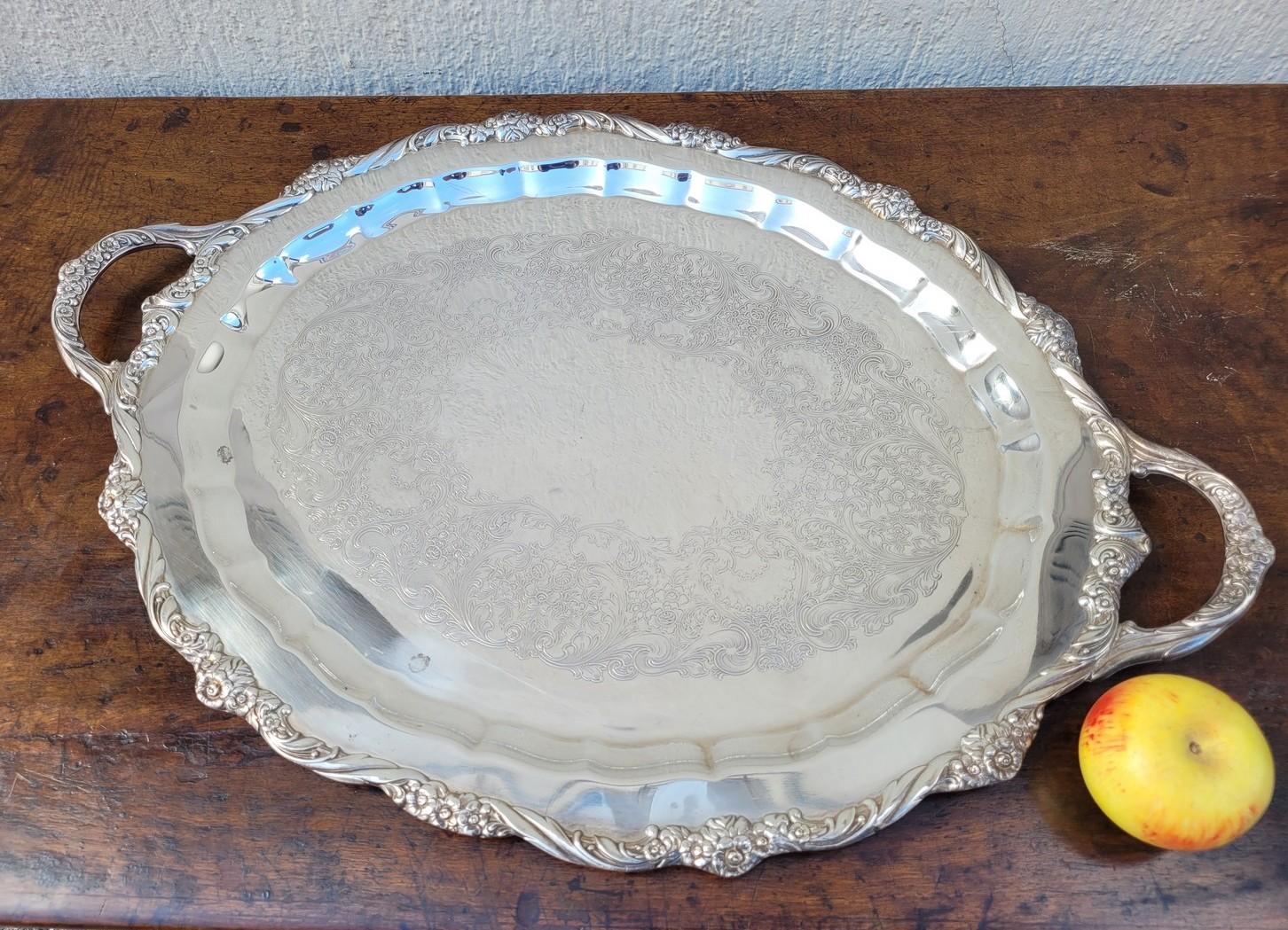 Plateau en métal argenté de forme ovale, avec poignées, avec décoration florale.

Traces d'utilisation, rayures et légers chocs.
20e siècle.

71 x 48 cm