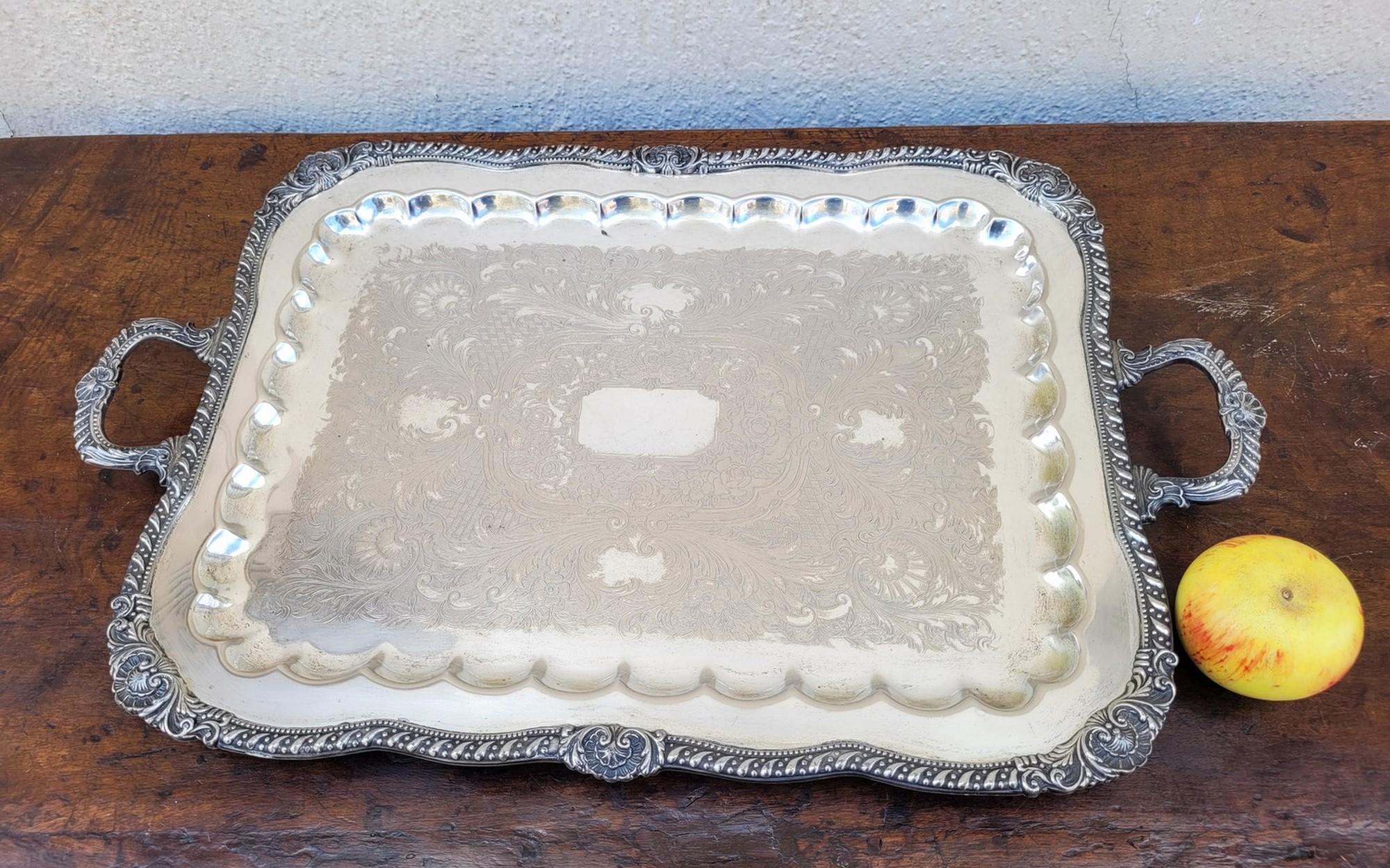 Plateau rectangulaire en métal argenté, avec pieds et poignées, décoré de fleurs et de coquillages

Traces d'utilisation et légers chocs.
20e siècle.

65 x 40cm.