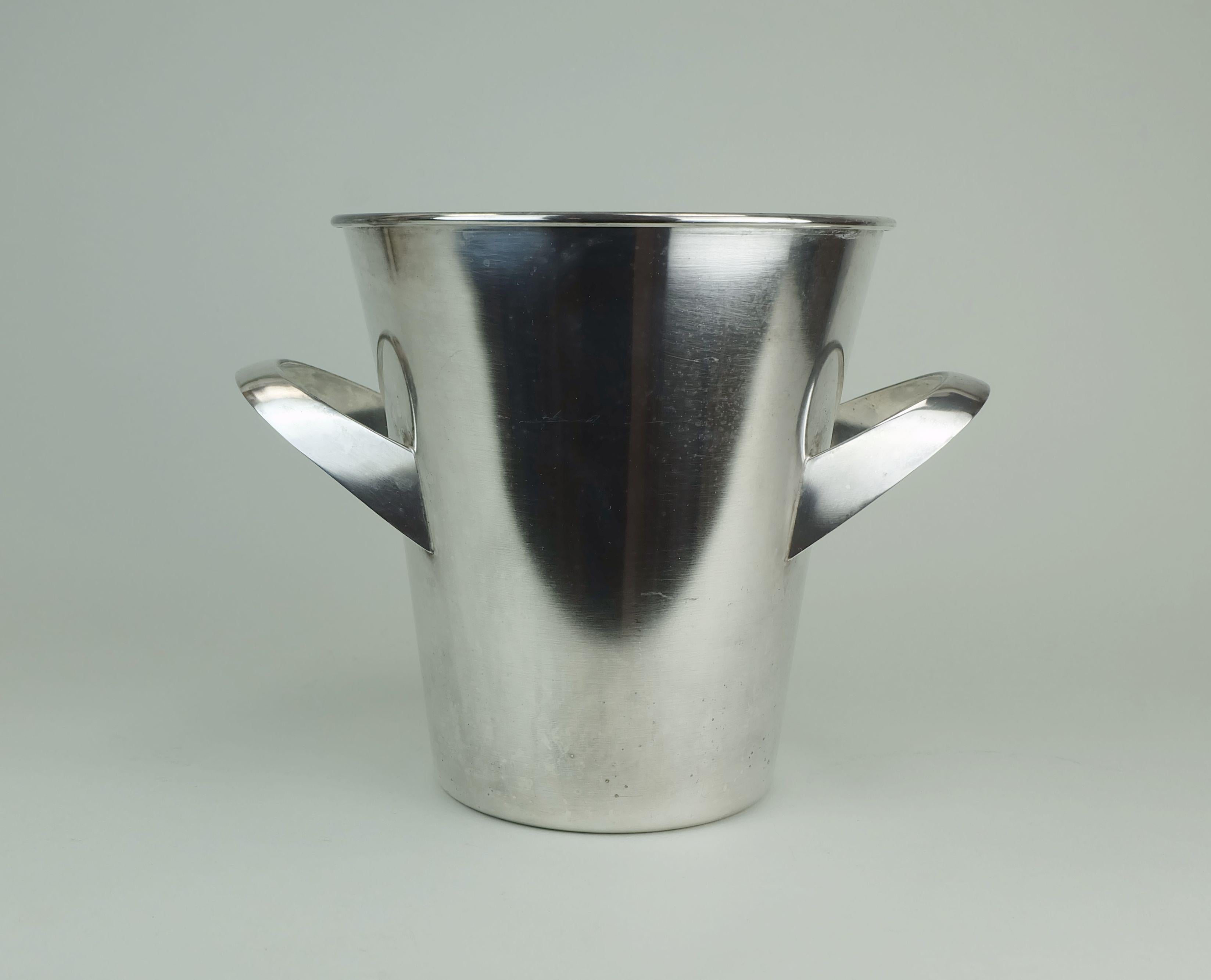 Eleganter Vintage-Champagnerkühler der Firma WMF. Entworfen von Kurt Mayer. Versilbertes Metall. Unten signiert WMF.

Abmessungen in cm:
Höhe 22 cm, Durchmesser oben 20,8 cm, Durchmesser unten 13,4 cm, Breite mit Griffen 28 cm.

Abmessungen in