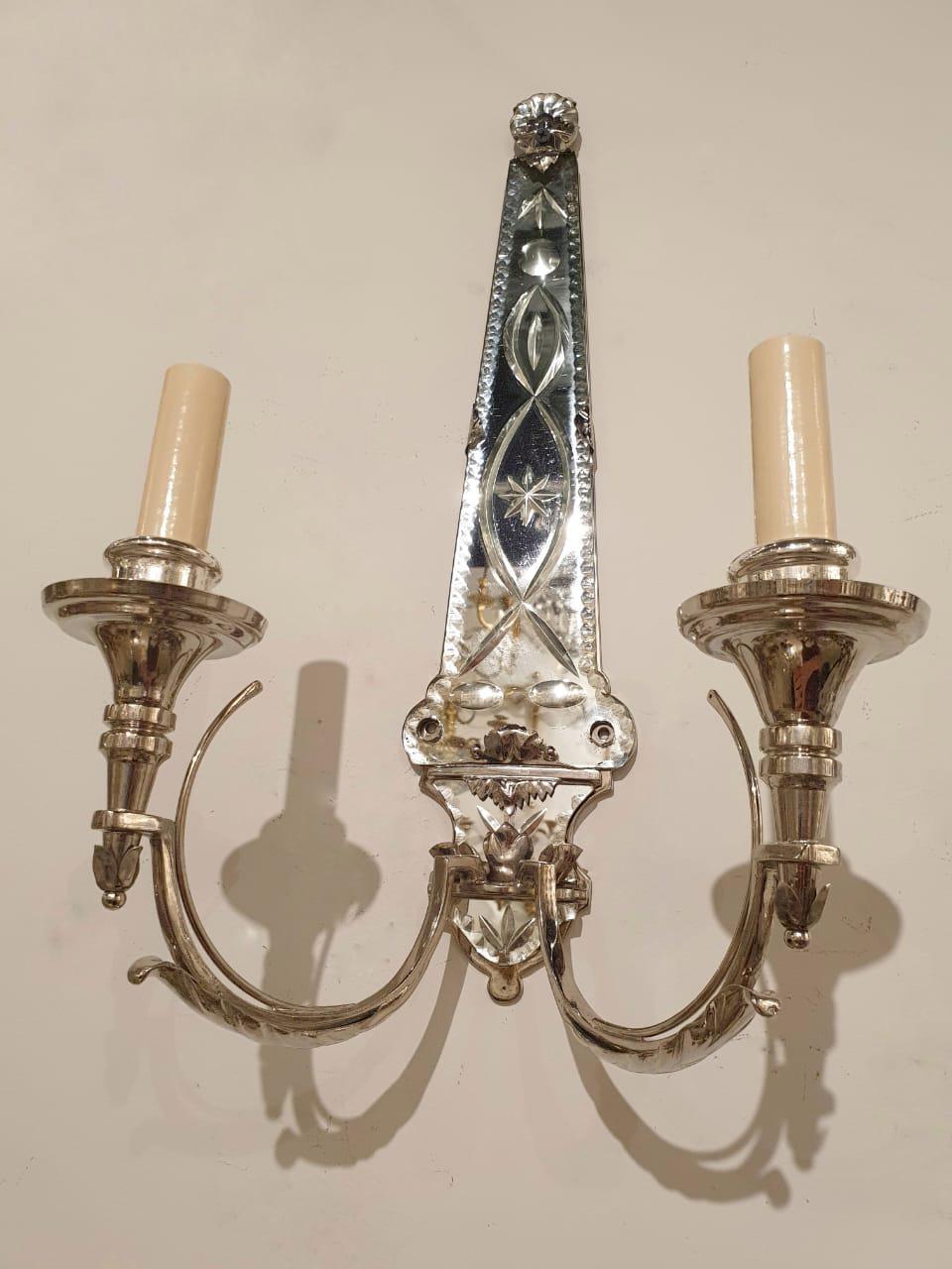 A pair of circa 1920’s silver plated mirrored backplate sconces with two lights, in French classic style. In great vintage condition. 

Dealer: G302YP 

