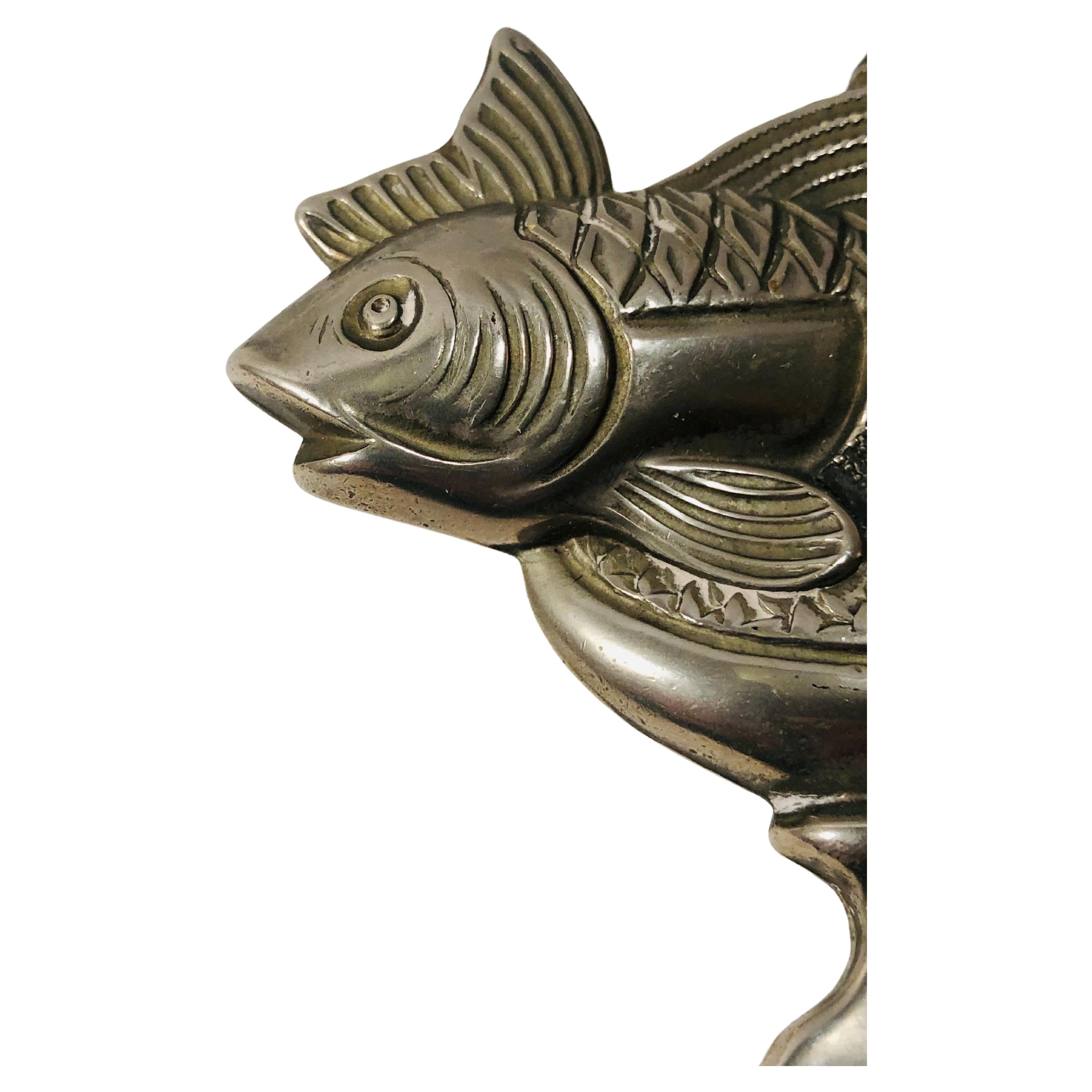 Ein Flaschenöffner aus den 1970er Jahren aus versilbertem Metall, der die Tierkreiszeichen darstellt, darunter das Zeichen Fische.

Ein funktioneller und dekorativer Gegenstand, ideal für Sammler oder Liebhaber von Vintage-Design und