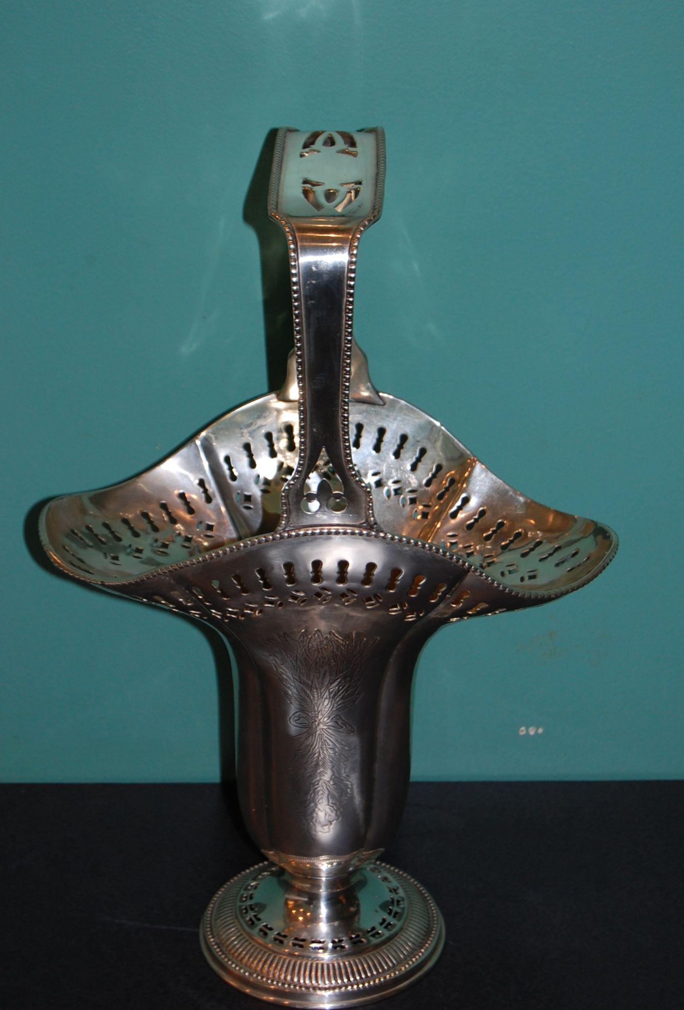 A fanciful silver plated vase with handle in very good condition recently polished and lacquered. The rim and the base have cut-outs and the front and back have engravings.