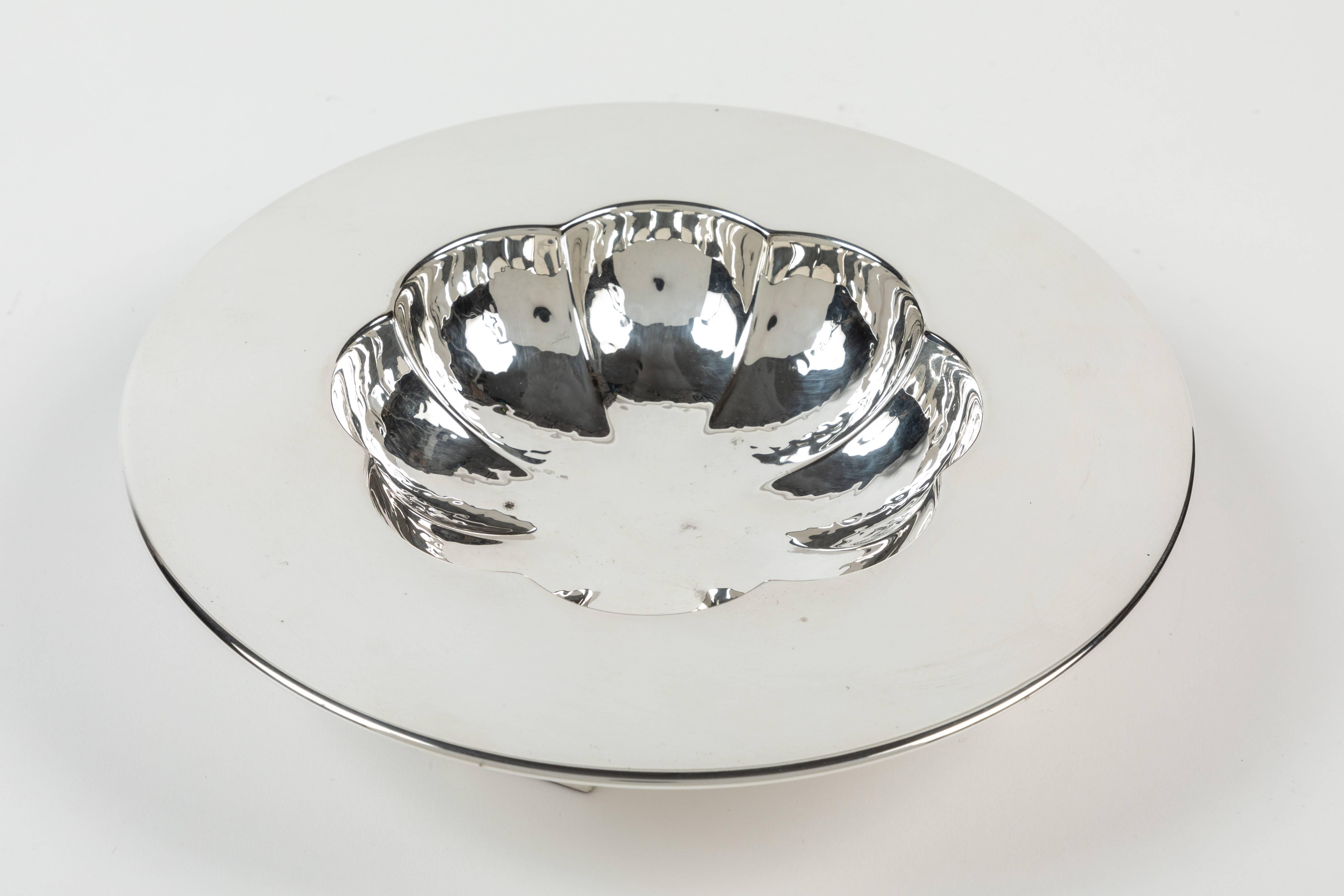 Here is a very famous design by Michael Graves for Swid Powell that is very difficult to find. The bowl is peen-hammered and sits on a fixed cruciform base. The initial drawings for this are in the Tapert book on page 40, and there is a photo of