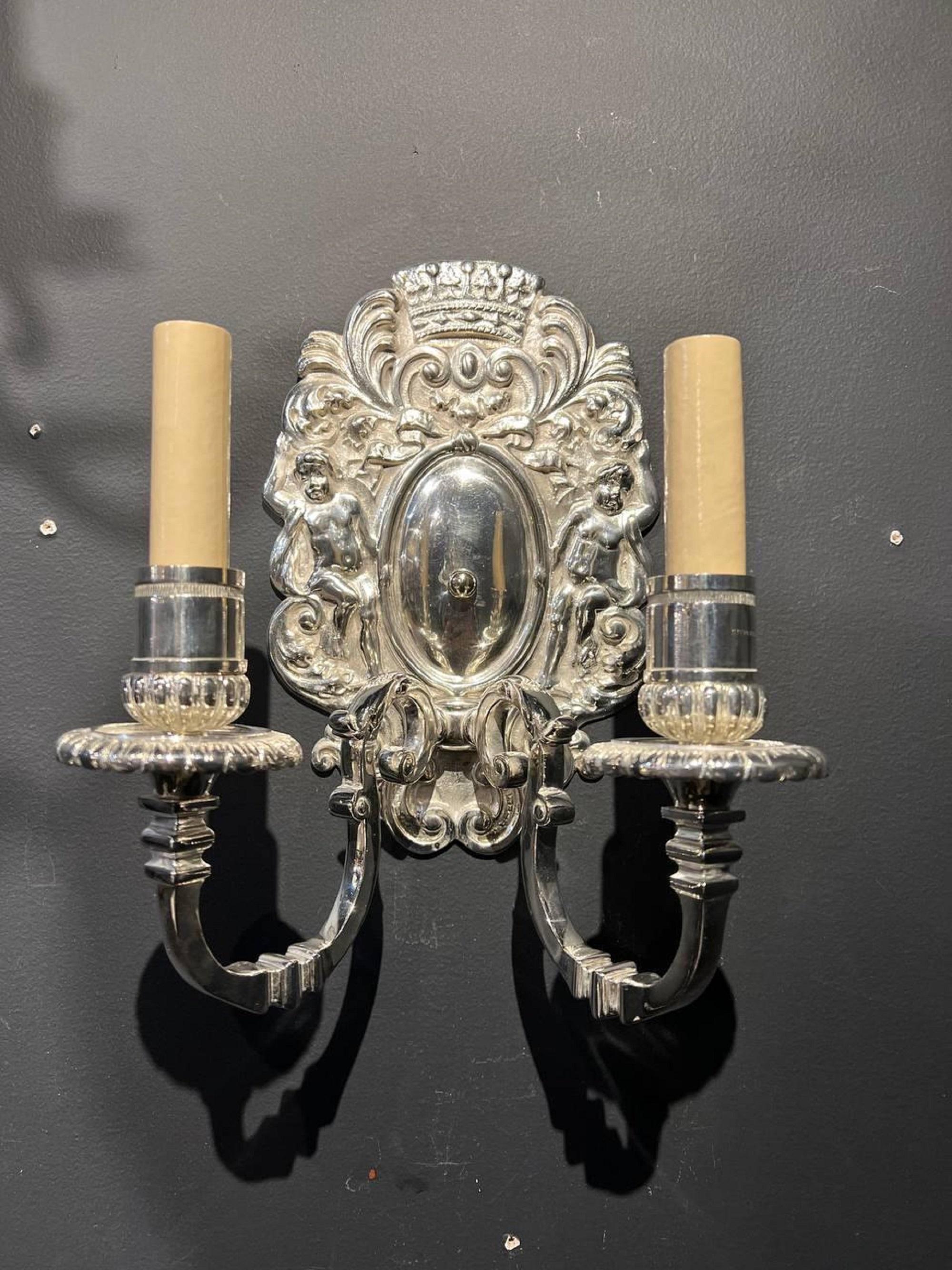 A pair of circa 1920’s silver plated sconces with cherubs on plate design and two lights.

Dealer: G302YP