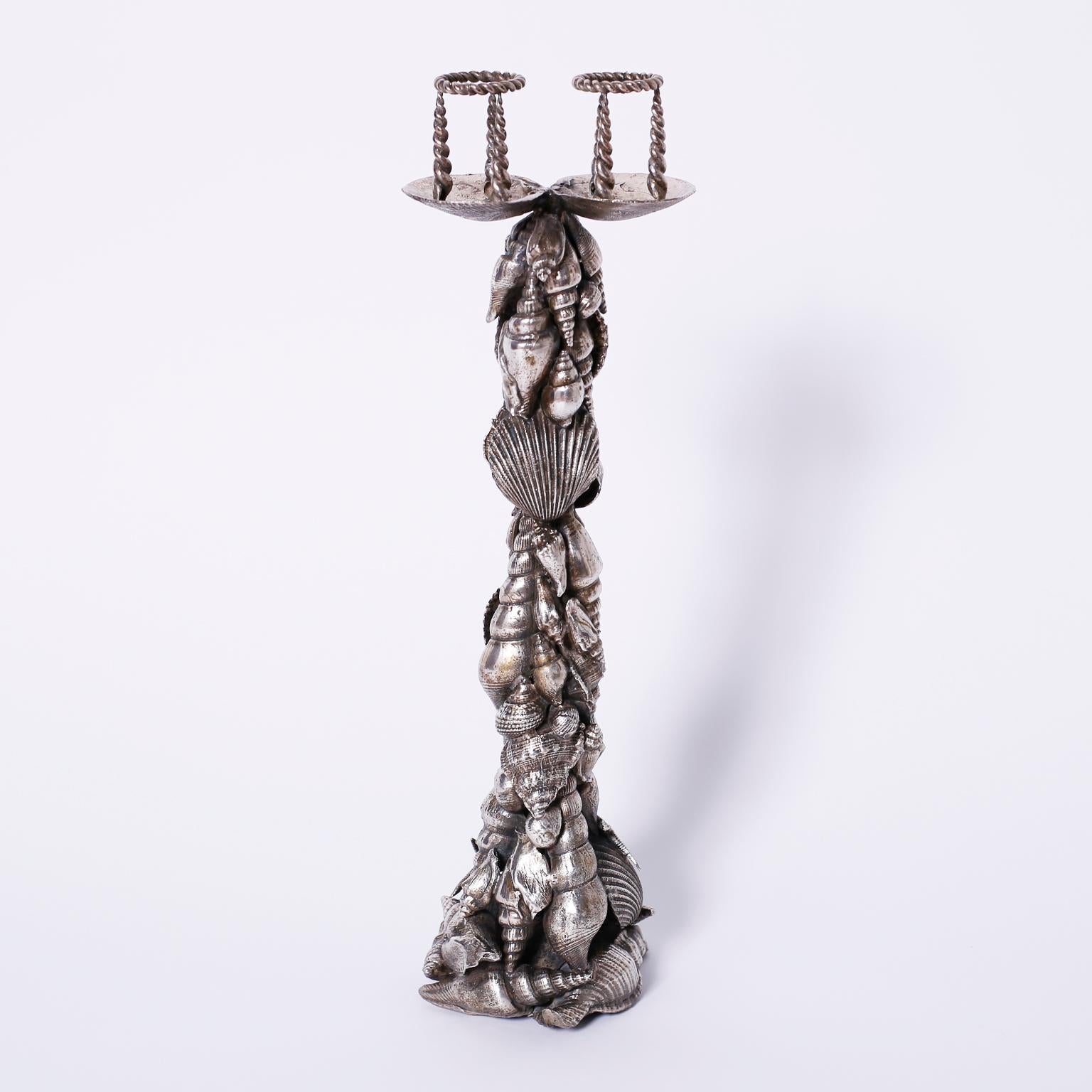 Silver plate on brass candlesticks or candelabra with two candle cups at the top over bases decorated with an abundance of seashells. Signed Maitland-Smith at the bottom.