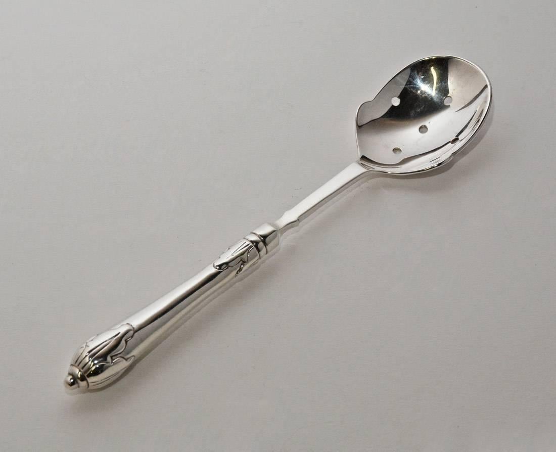 The vintage silver plated serving spoon has a pierced bowl for draining liquids and a decorative handle. Stamped The Source Perrier Collection.