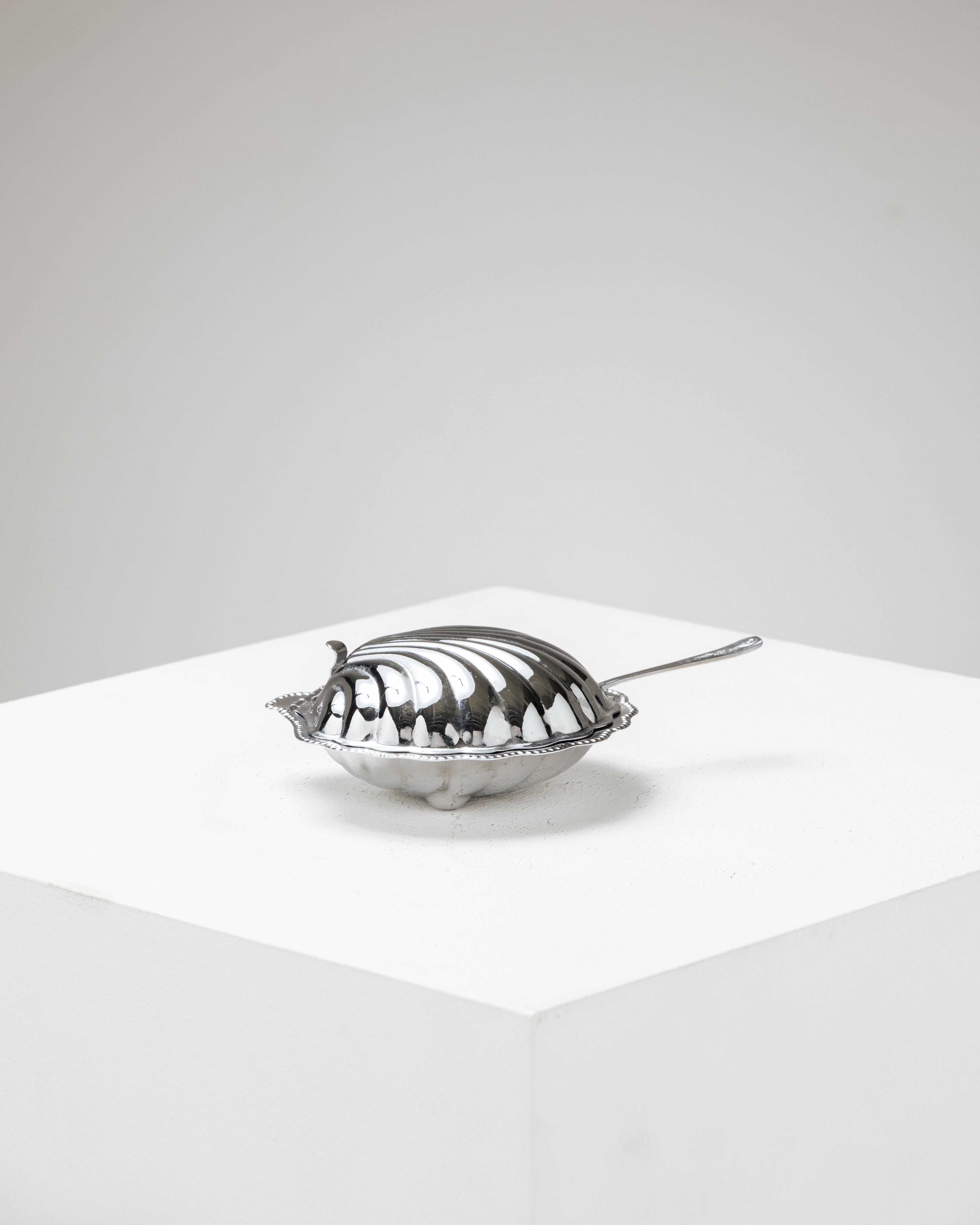 Silver-plated shell butter dish from the 70s.
Composed of a silver-plated metal dish, a matching lid, and the original knife. It features a removable frosted glass insert. Slight patina on the metal, overall good condition.

LP5475